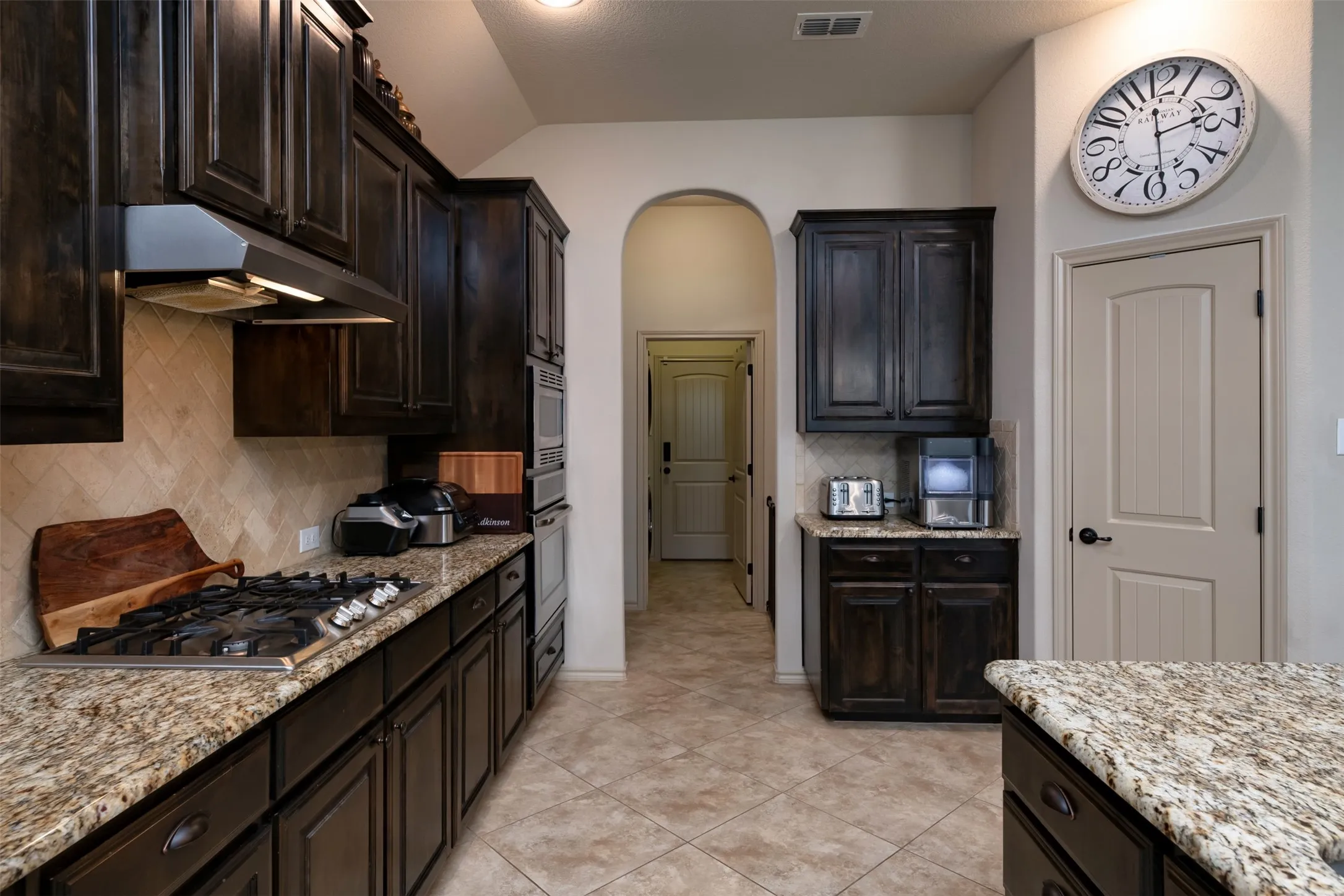 Another view of the kitchen area highlighting the pantry and additional cabinet and countertop in space.