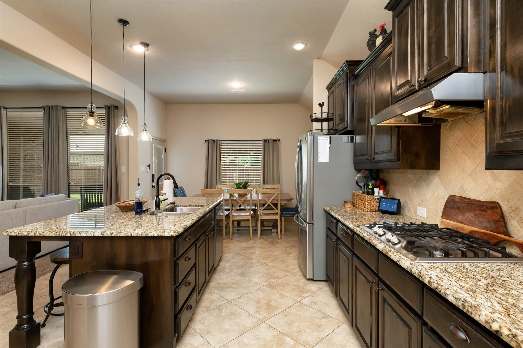 A view of the kitchen looking back toward the dining area and rear of home.