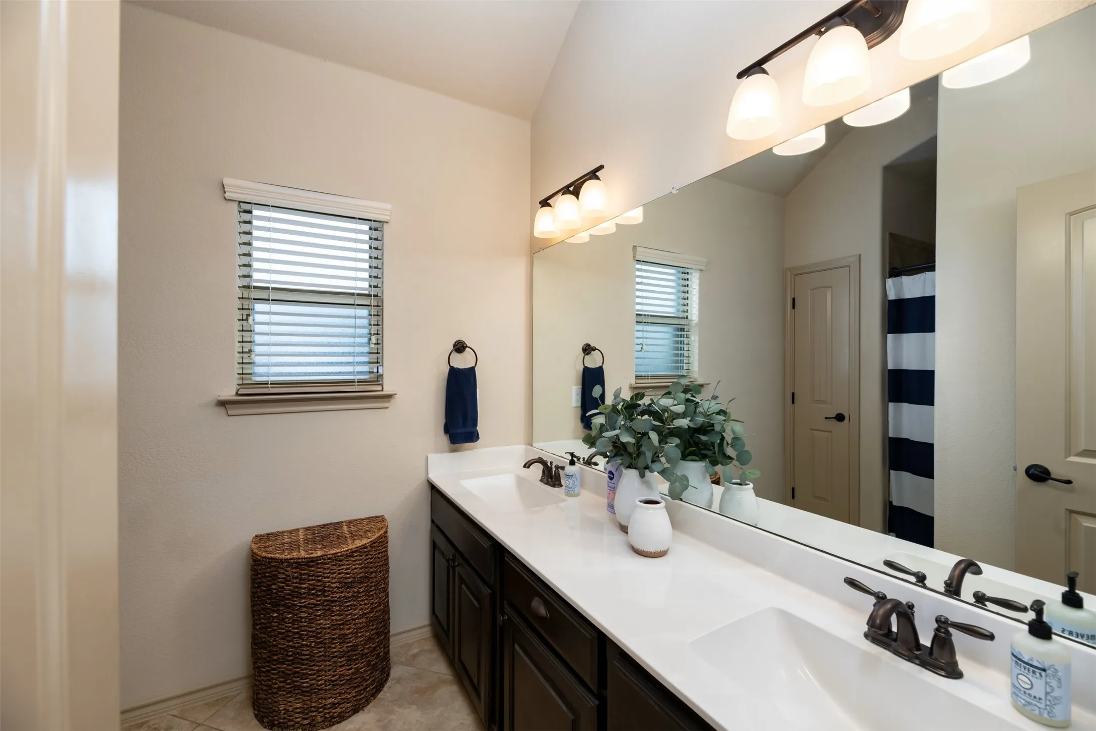 Hallway bath features dual sink vanity area with tub and shower.