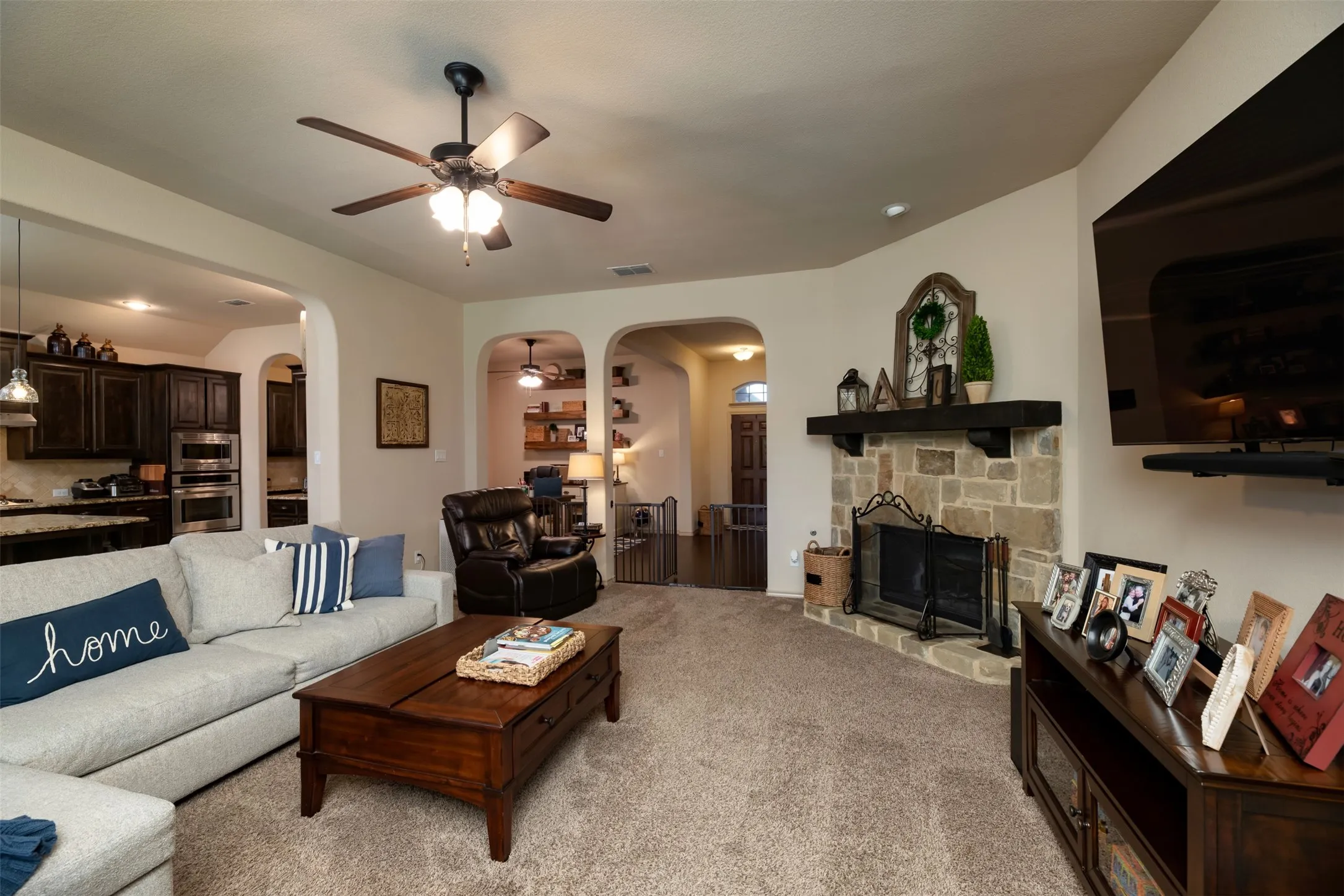Living area with a view of the gorgeous rock stone fireplace with mantle. Stone matches front exterior stone on building.