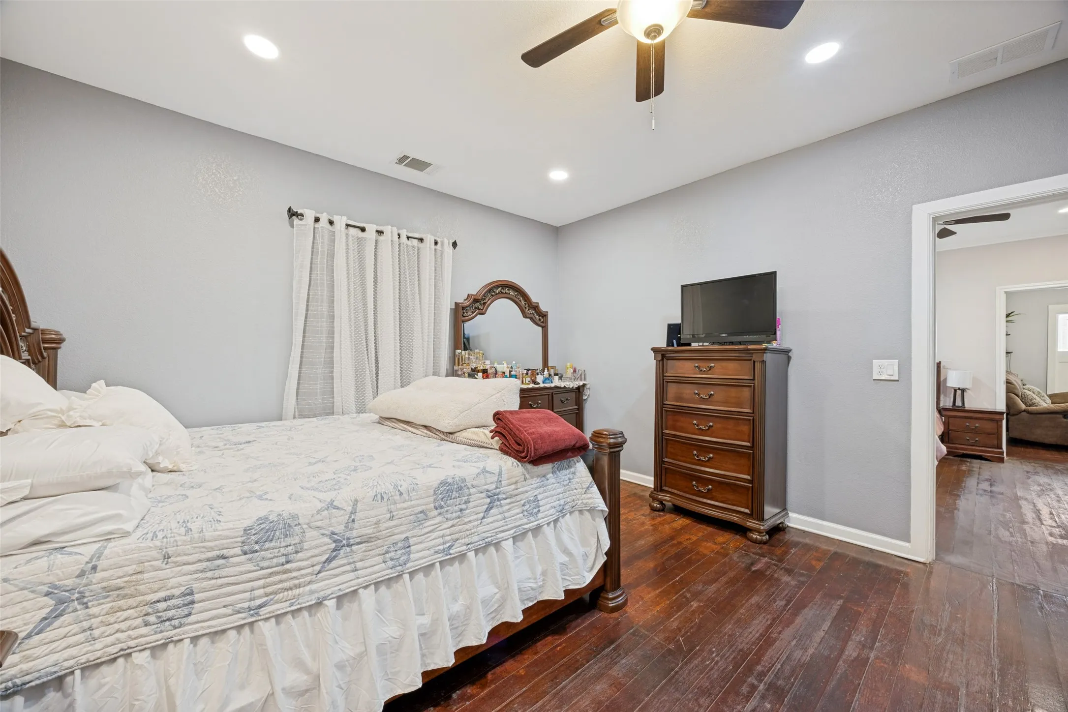 Spacious room featuring wood-finish flooring, recessed lighting, and a ceiling fan