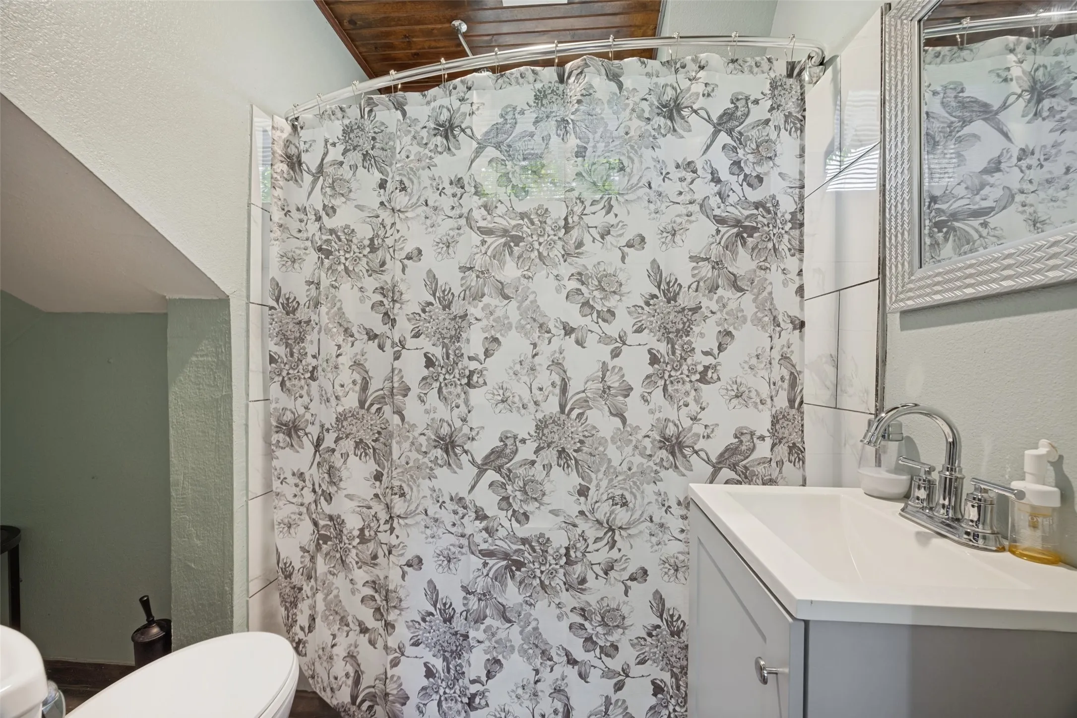 Bathroom with a light gray vanity, integrated white sink, and chrome faucet