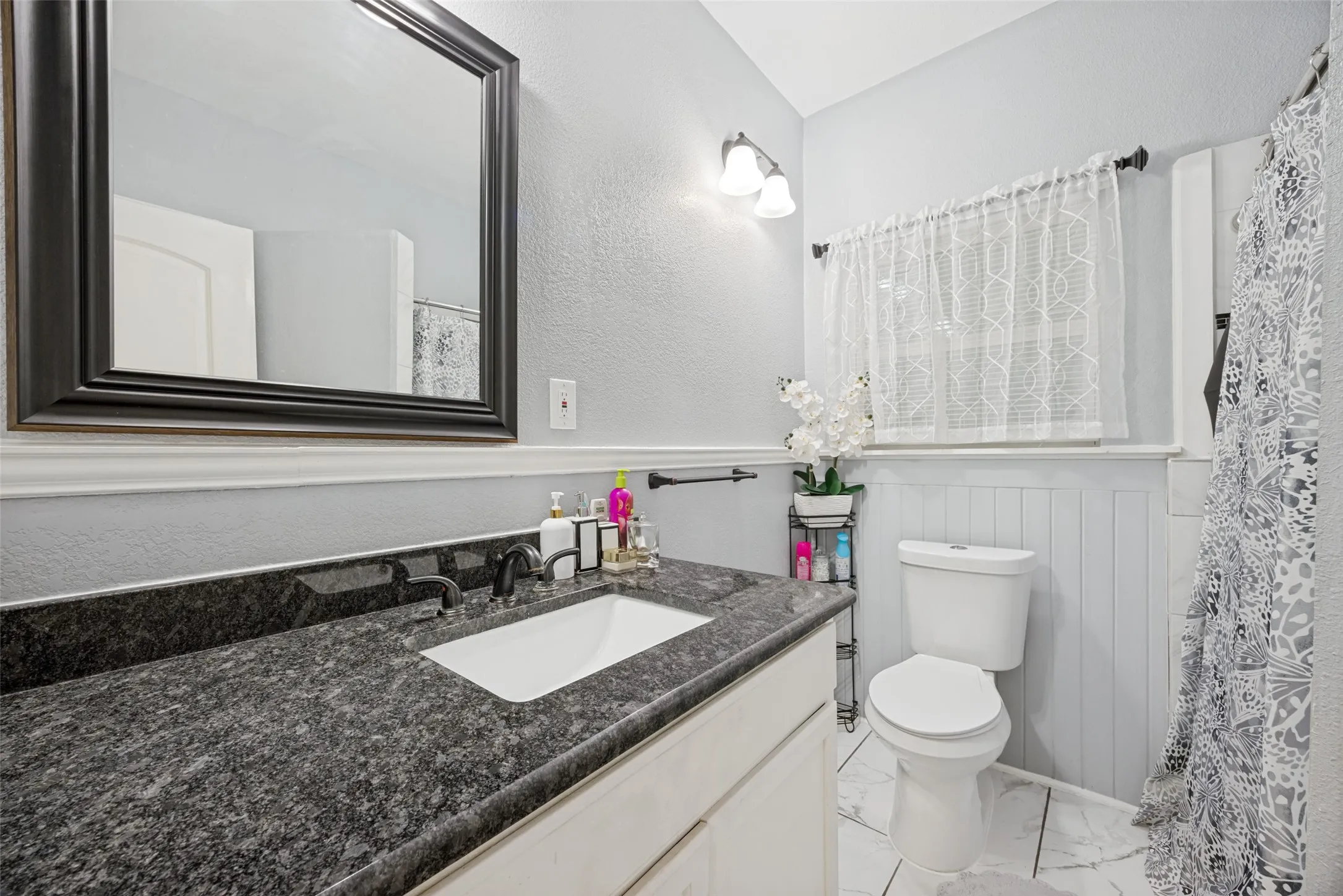 Vanity with a dark speckled countertop and undermount sink