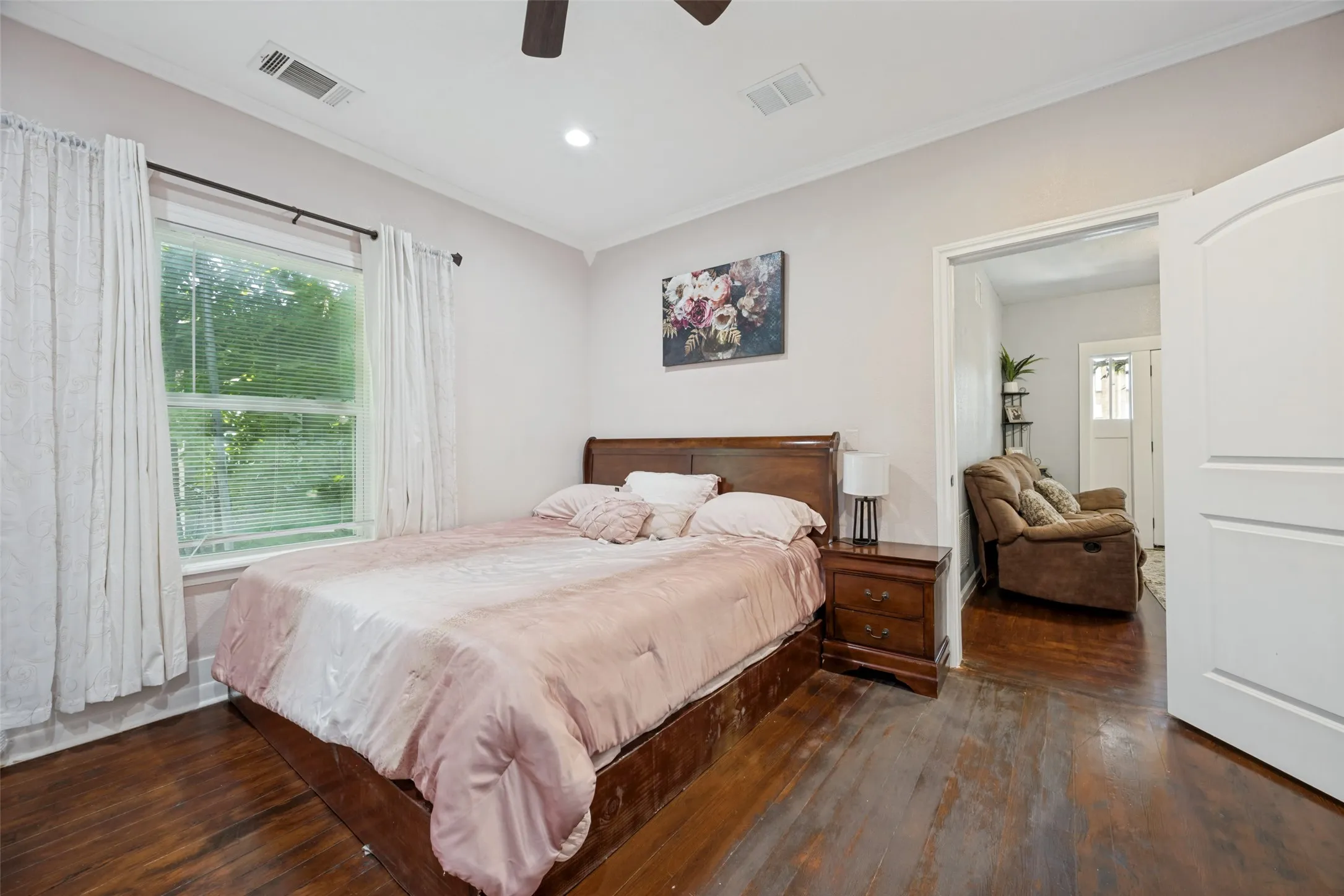 Bedroom featuring wood-finish flooring, a window with exterior views, crown molding, a ceiling fan, and recessed lighting