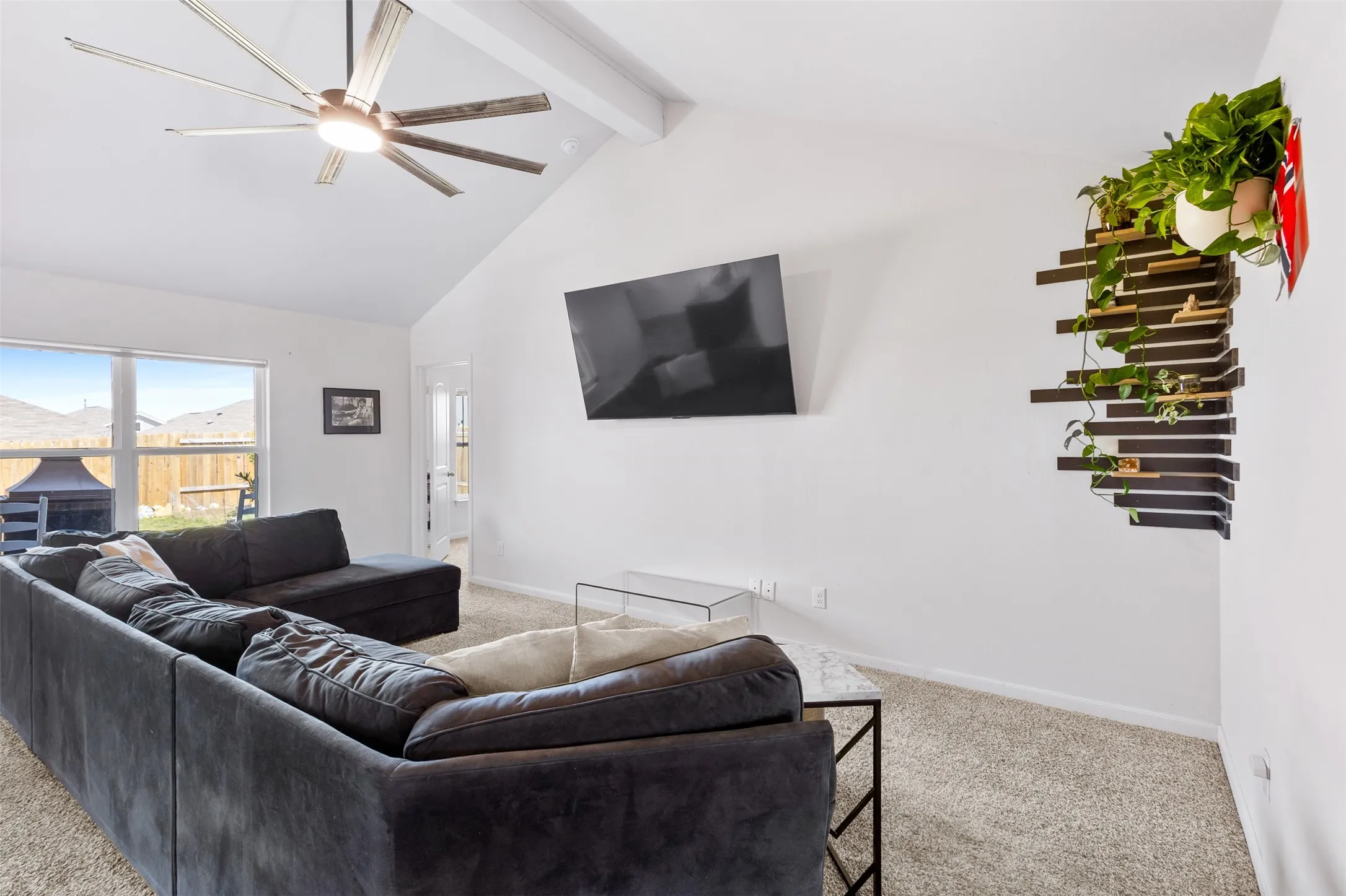 Vaulted ceiling with an exposed beam and a contemporary ceiling fan