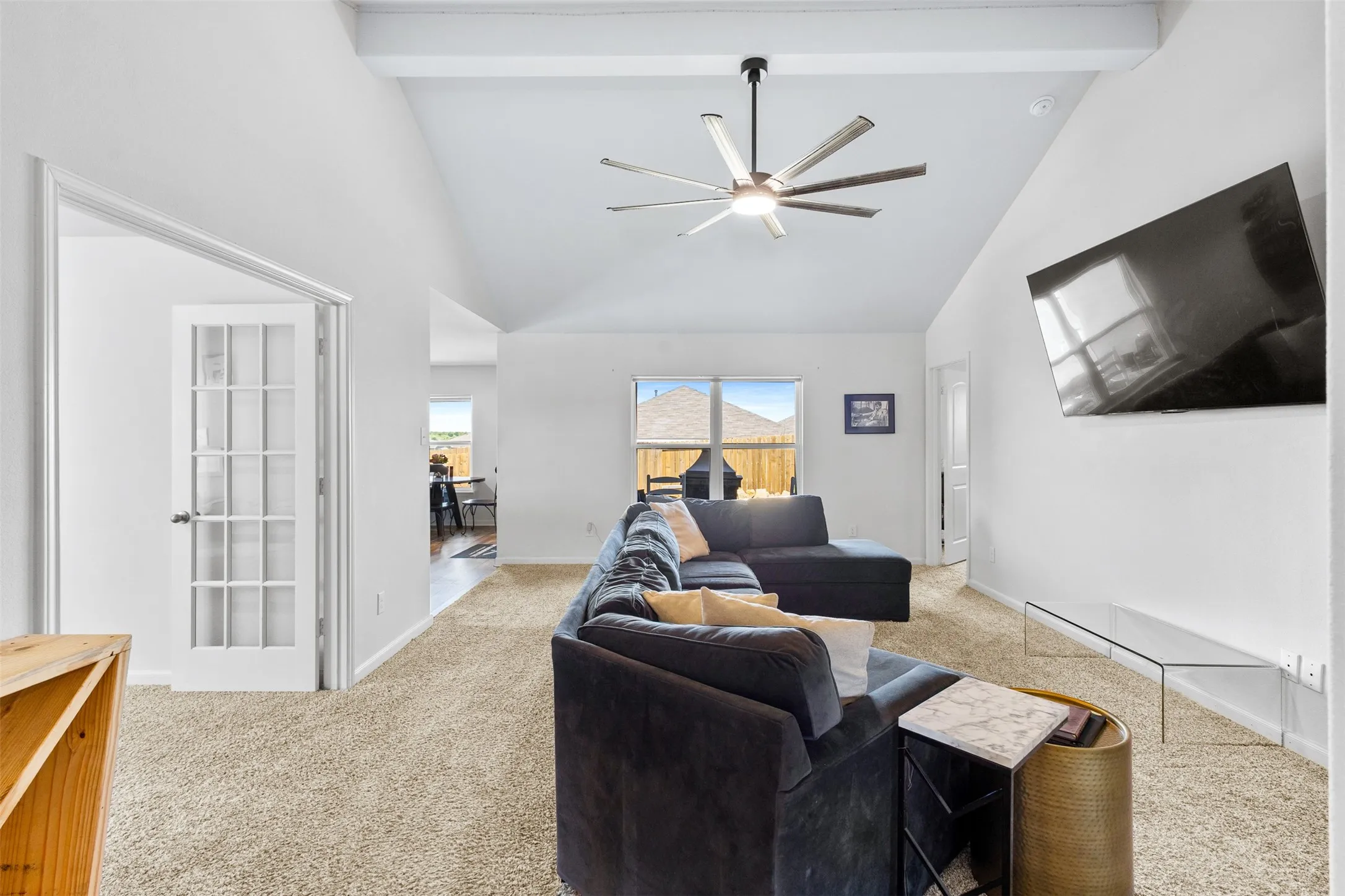 Vaulted ceilings with exposed beams and a contemporary ceiling fan