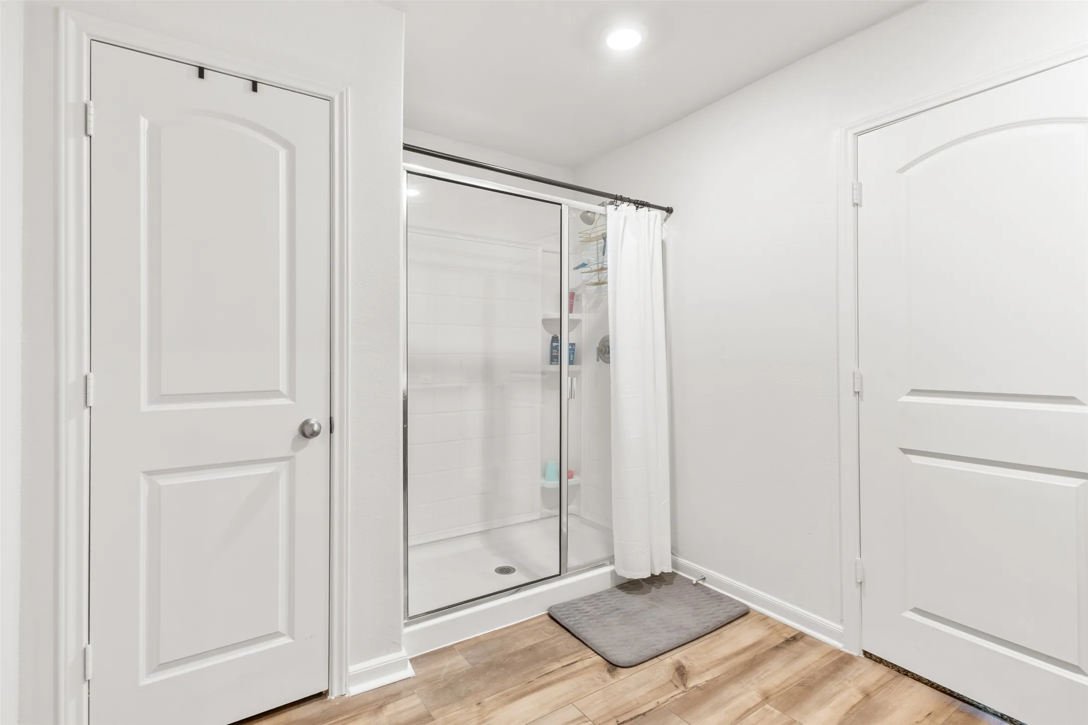 Frameless glass shower enclosure with a sliding door and white subway tile surround