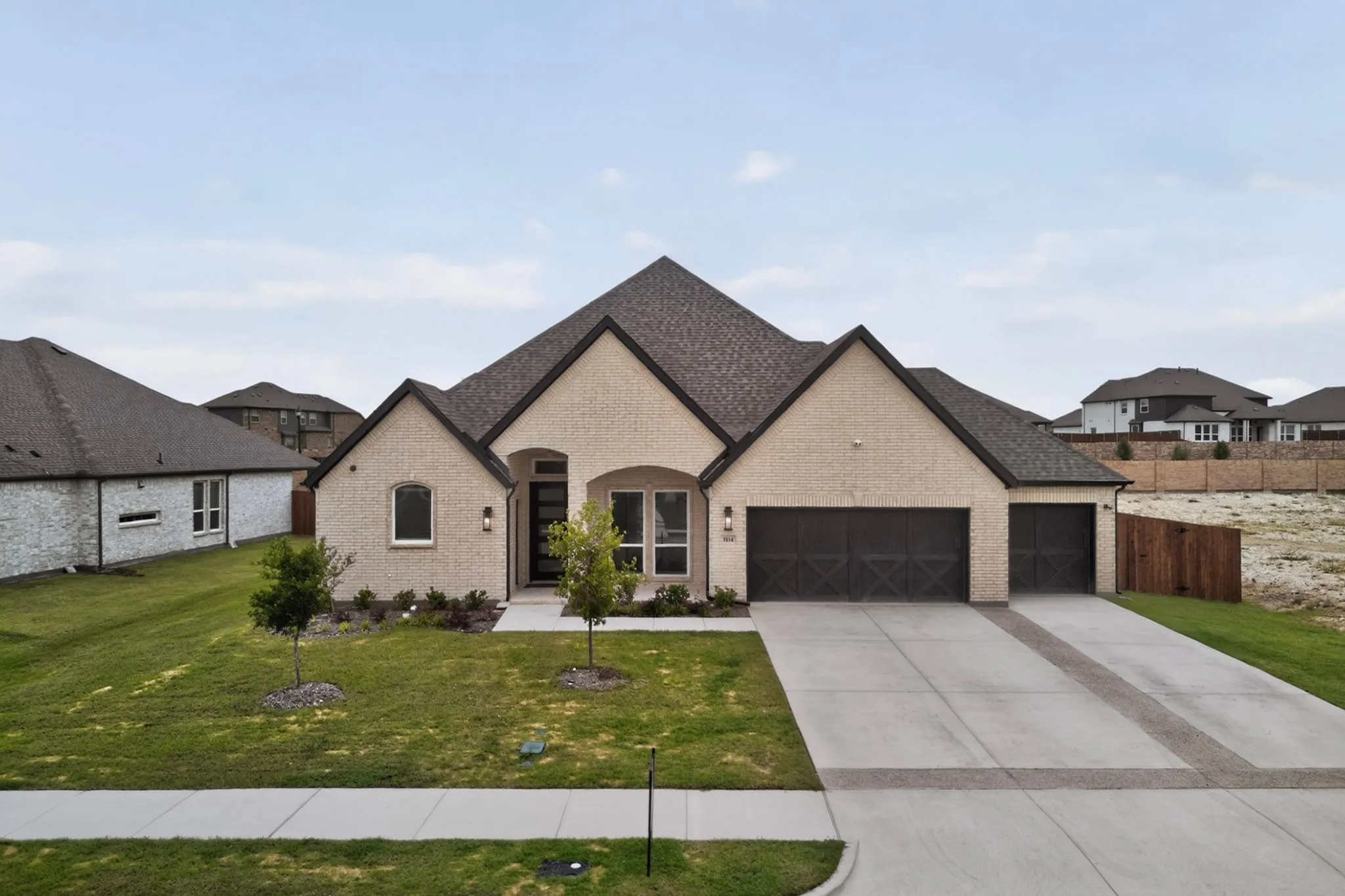 Contemporary single-story residence featuring a light brick facade and a dark shingle roof
