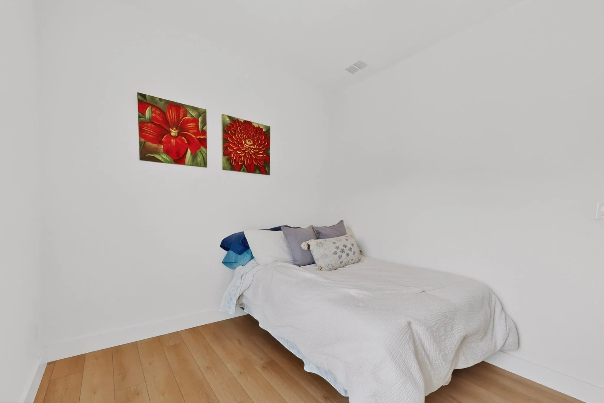 Room featuring wood-finish flooring, white baseboards, and neutral wall tones