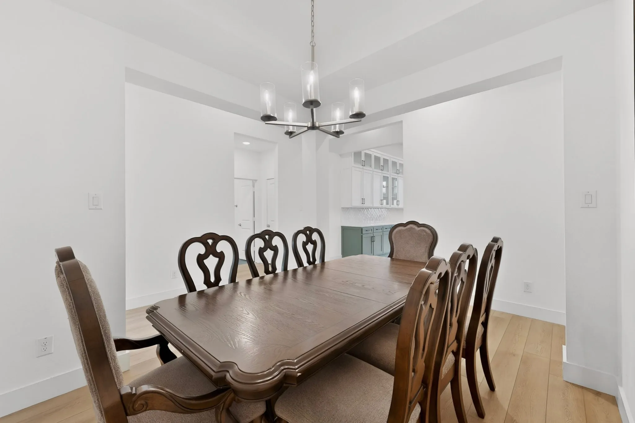 Dining area featuring light wood-finish flooring and a contemporary chandelier
