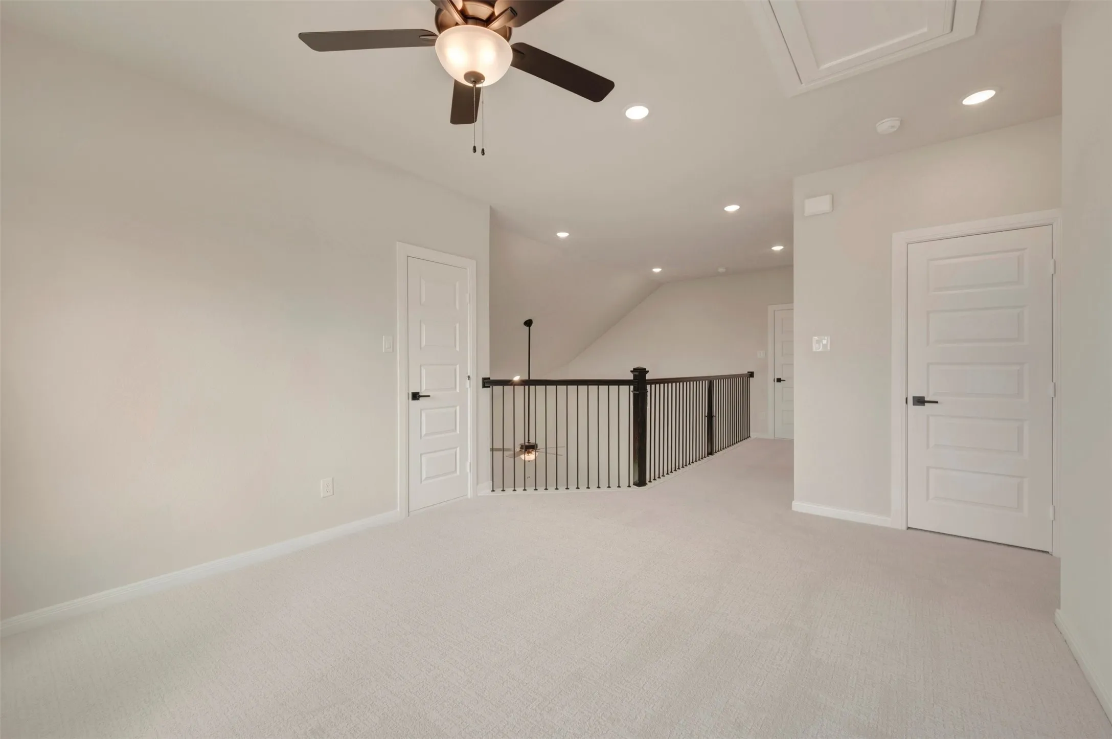 Recessed lighting, ceiling fan, carpeted flooring, white paneled doors, and black wrought iron balusters