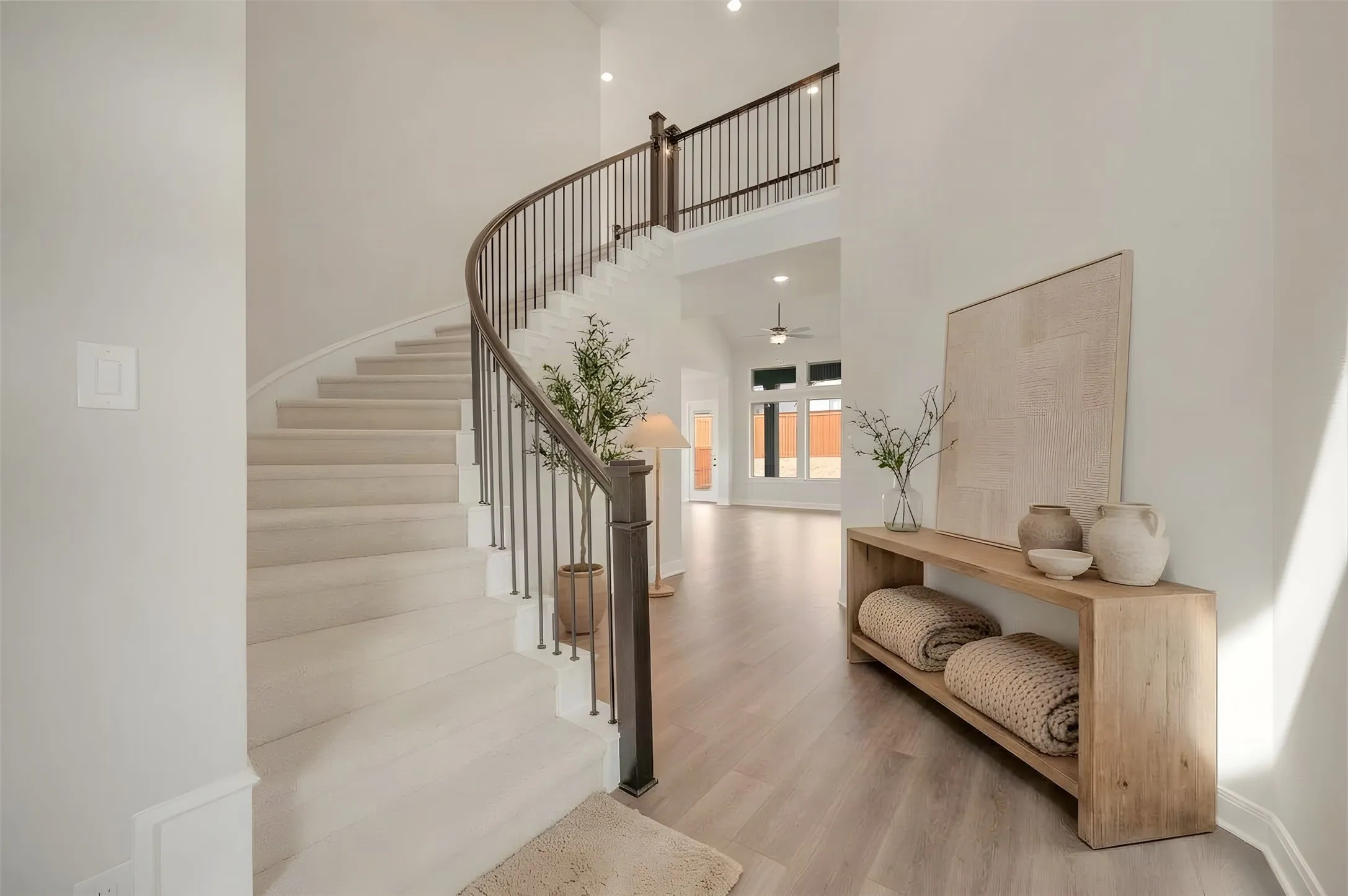 Curved staircase with wood-finish handrail and metal balusters