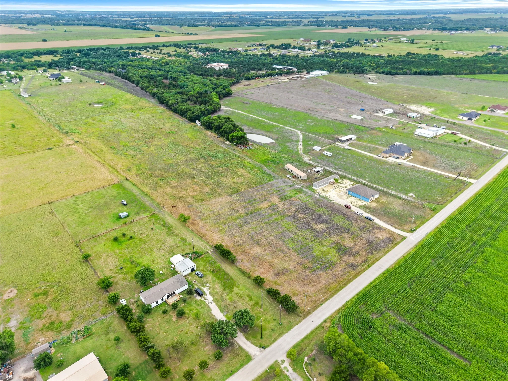 Expansive rural landscape featuring a mix of cultivated fields and undeveloped land