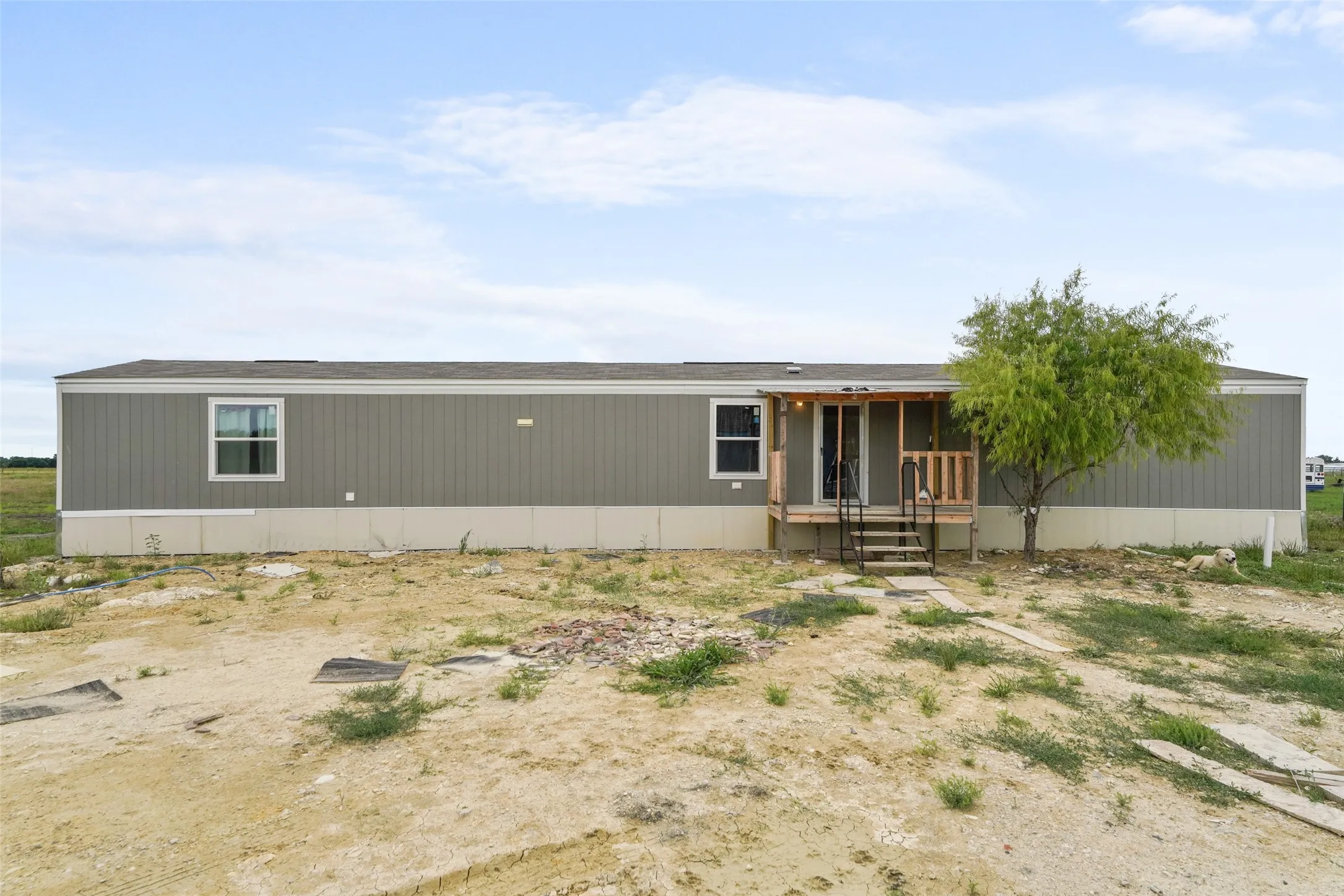 Single-story residence featuring gray vertical siding and a tan foundation
