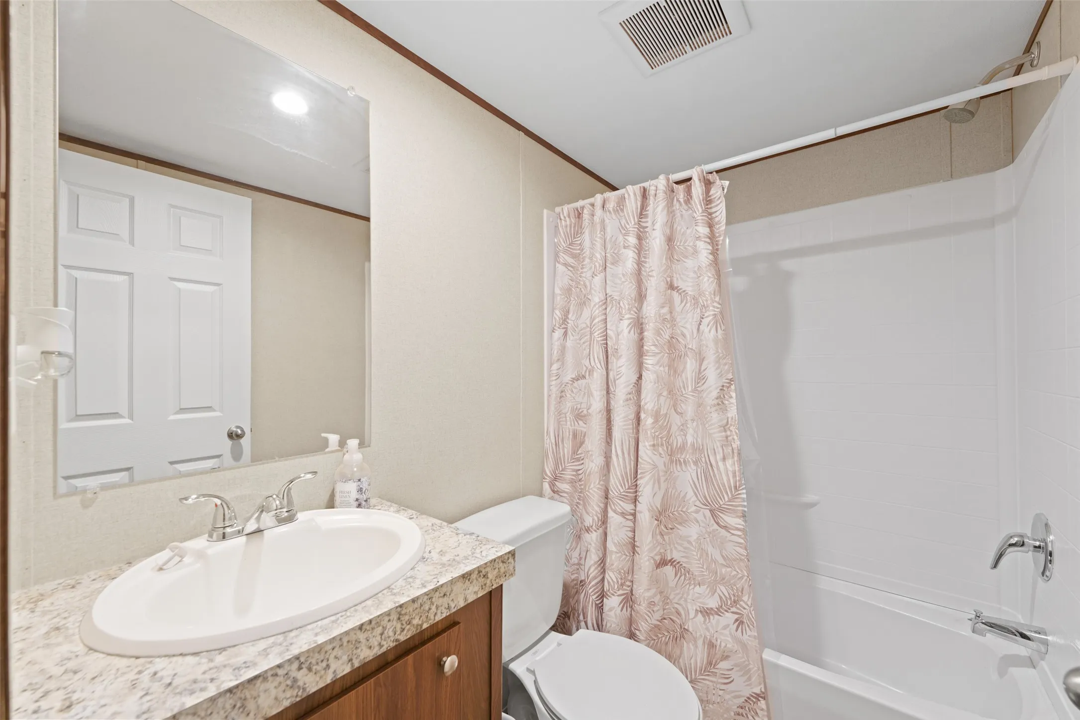 Bathroom featuring an integrated bathtub and shower with chrome fixtures