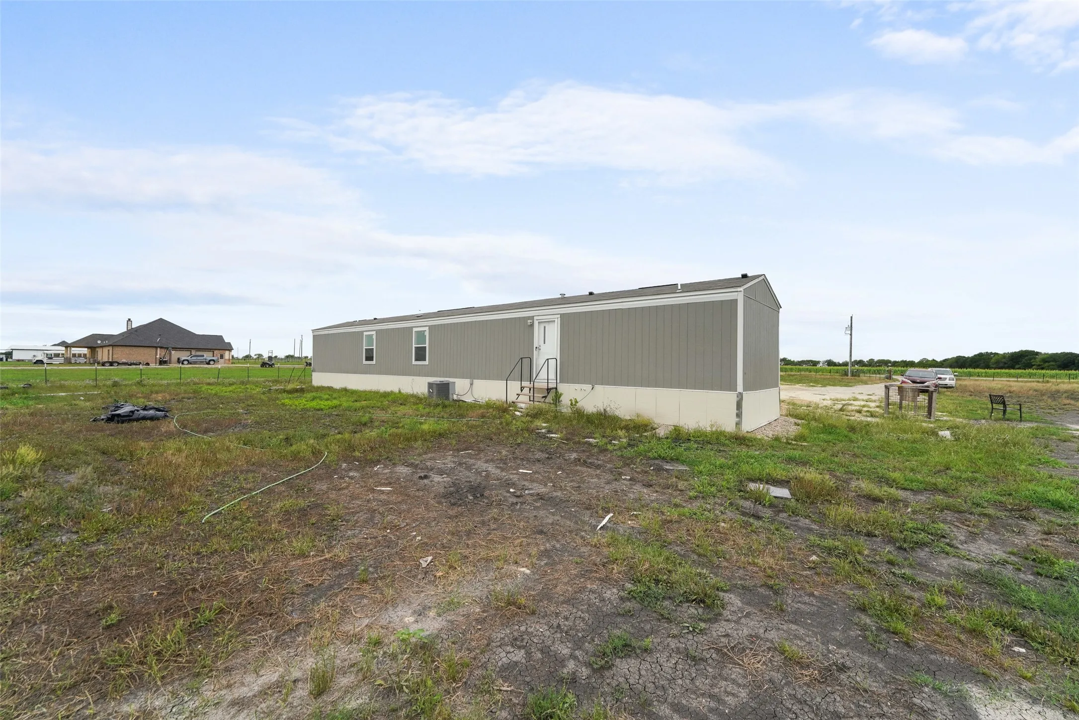 Single-story structure featuring a light gray siding and a contrasting darker gray roof
