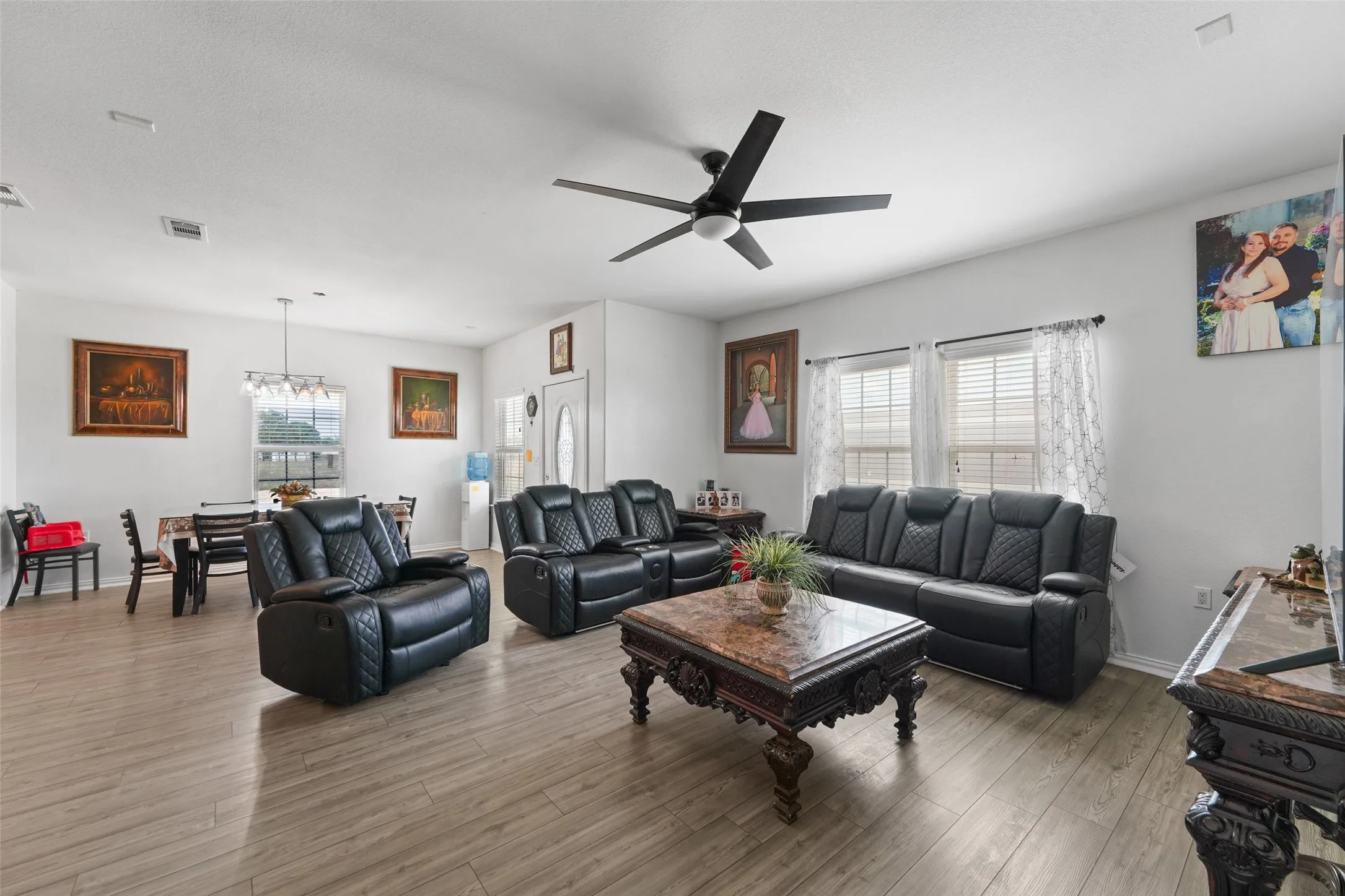 Open-concept living area with wood-finish flooring, recessed lighting, and a modern ceiling fan