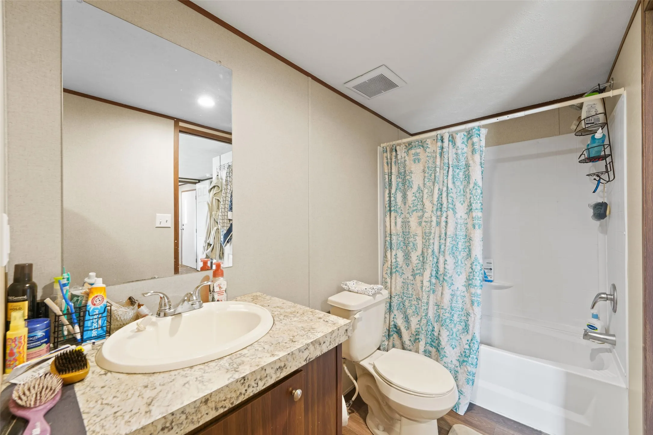 Bathroom featuring a vanity with an integrated sink, a speckled countertop, and wood-finish cabinetry