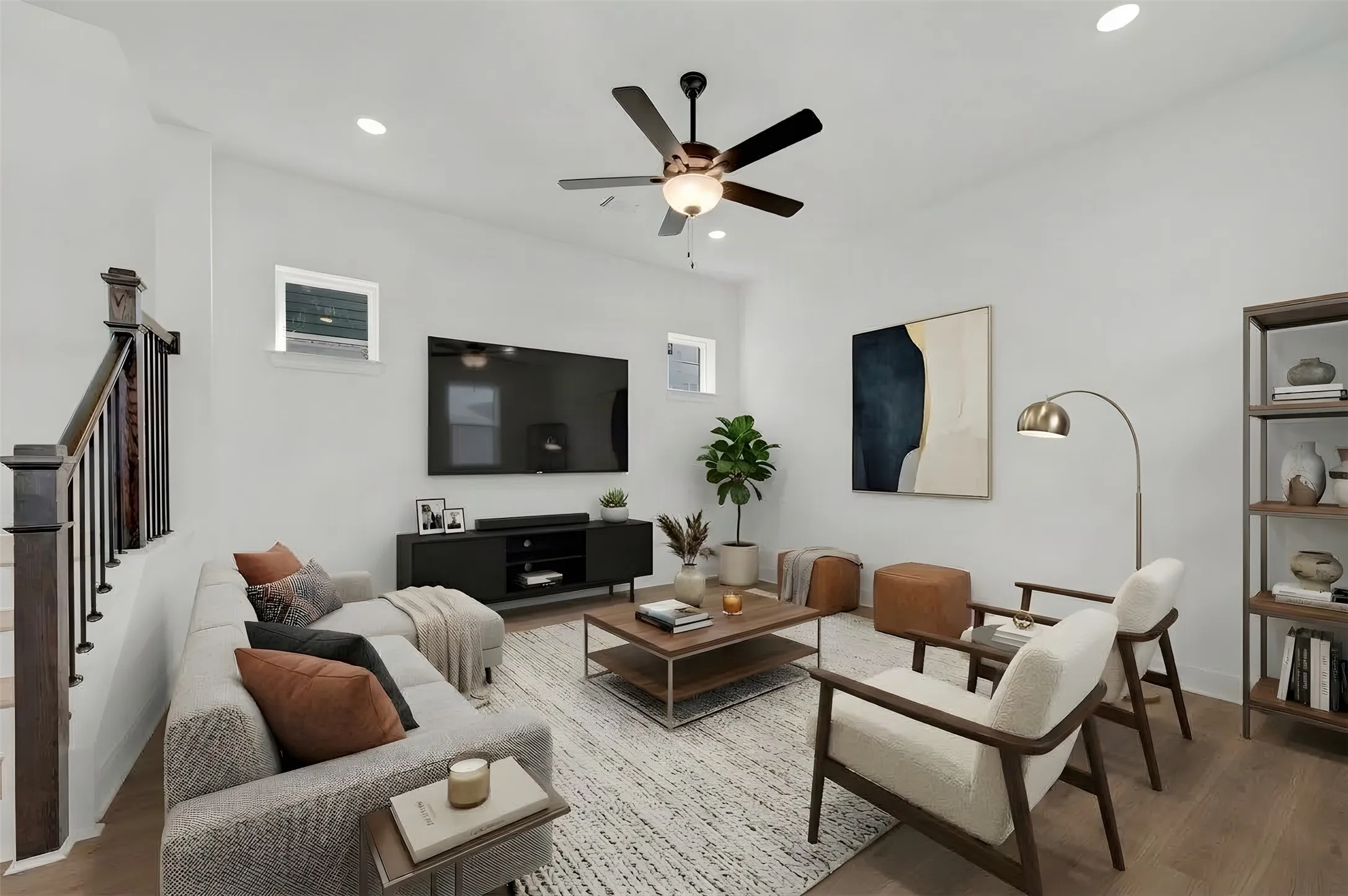 Spacious living area featuring wood-finish flooring, recessed lighting, and a ceiling fan