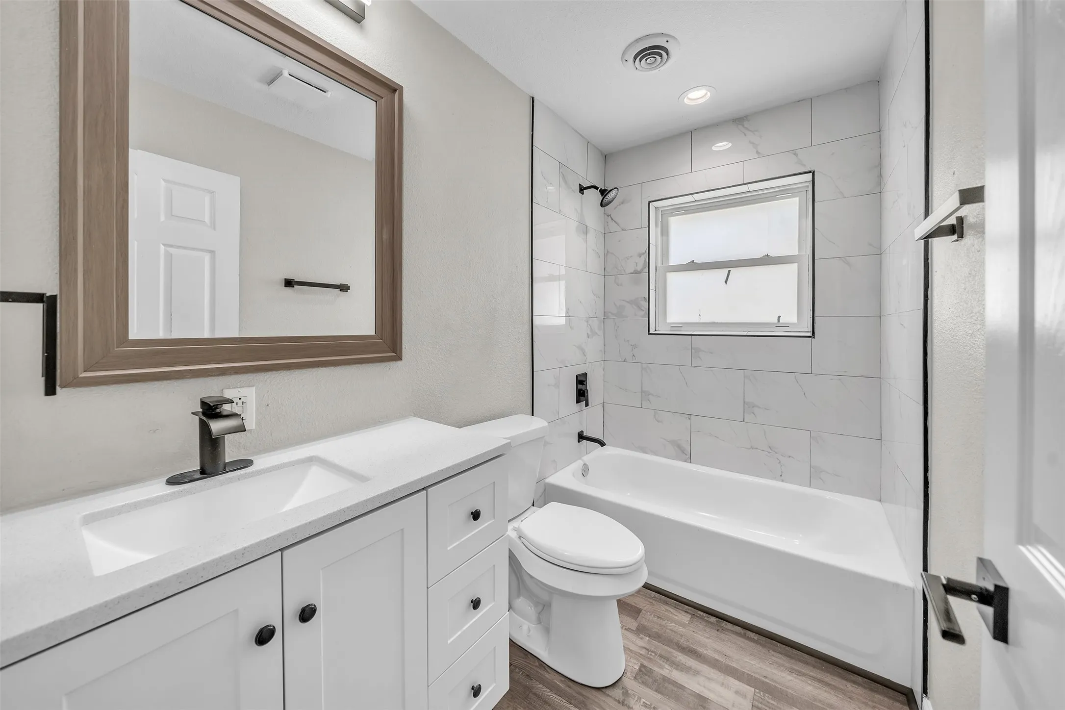 Updated secondary bathroom with modern finishes, spacious vanity and tub-shower combination.