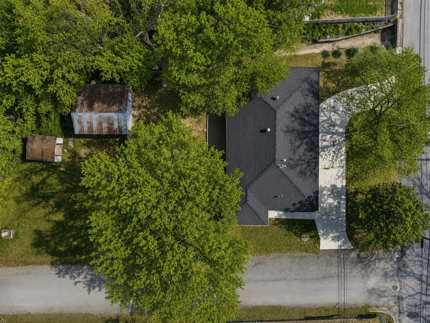 Front exterior of this Bowie, Texas home with mature trees and a circular driveway.
