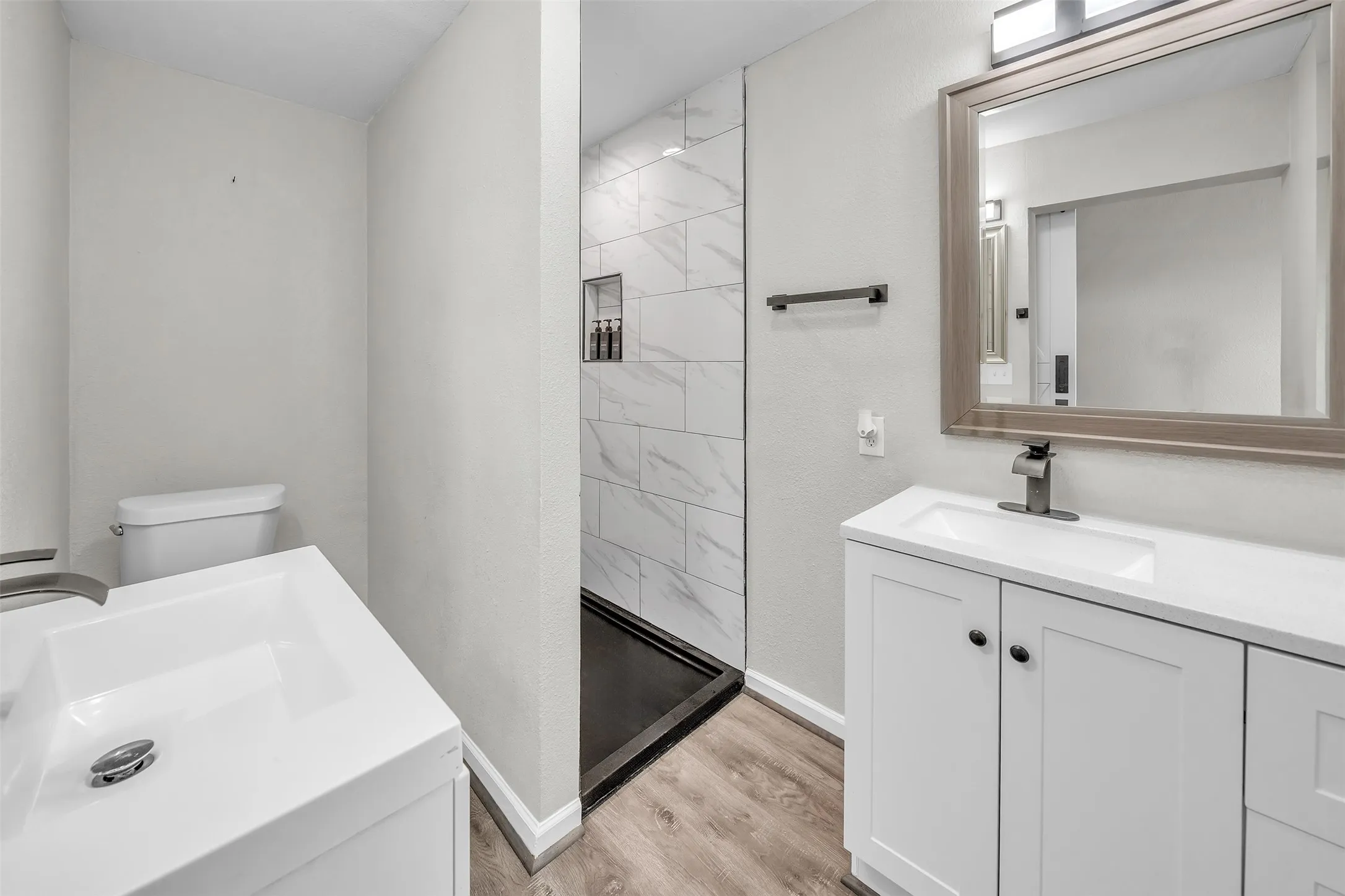 Updated bathroom featuring a spacious vanity, modern finishes and walk-in shower.