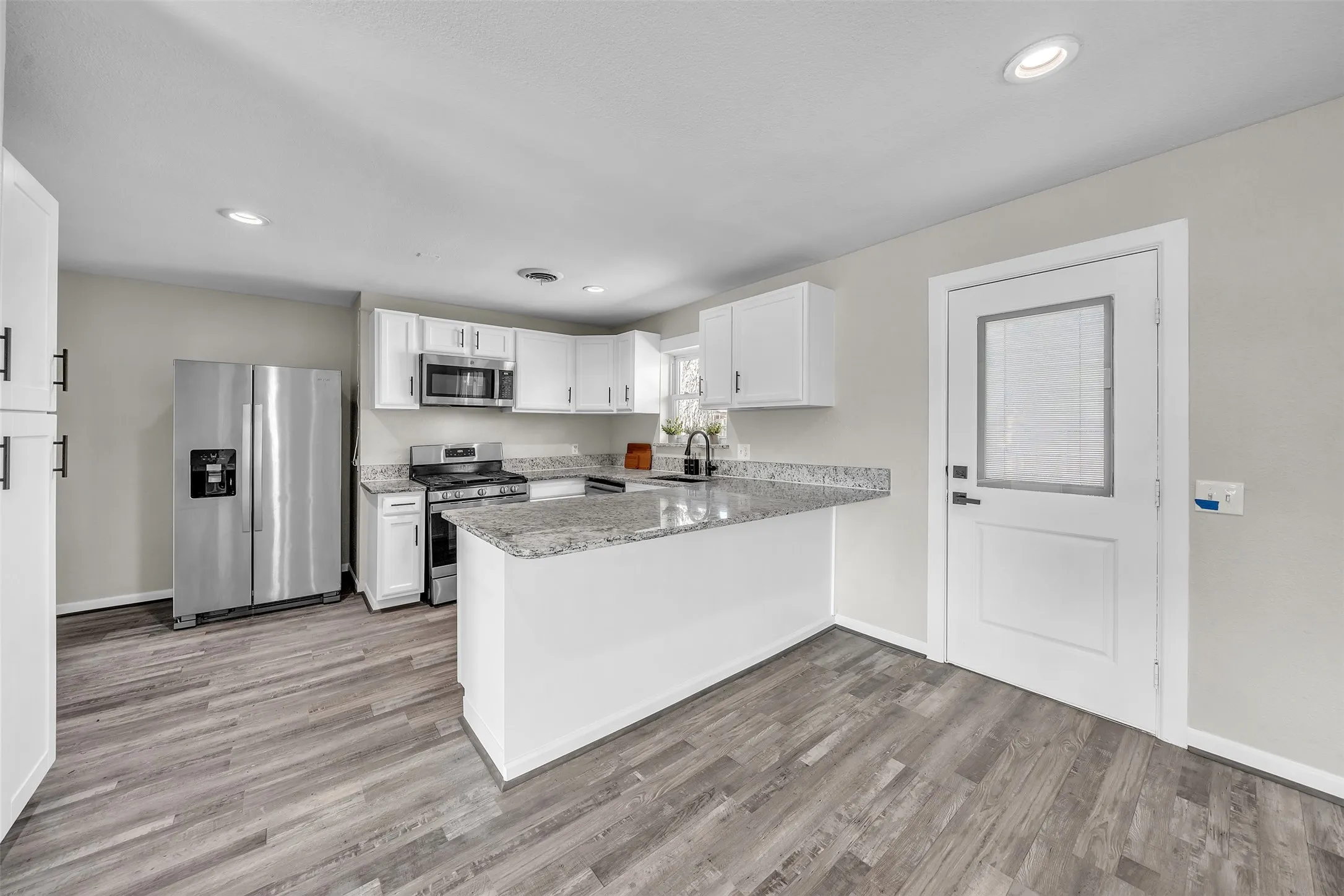 Updated kitchen featuring granite countertops and generous workspace.
