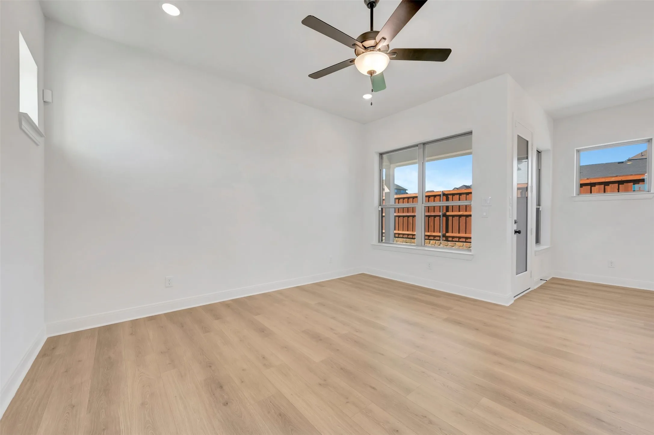 Recessed lighting, wood-finish flooring, ceiling fan, multiple windows, and a glass-paneled exterior door
