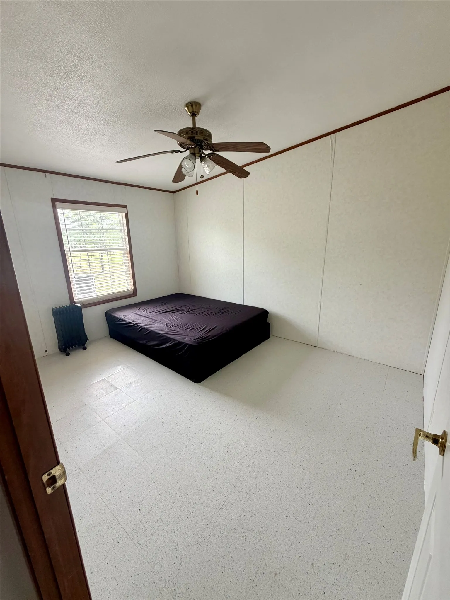 Room featuring light-toned flooring, white walls, and a ceiling fan with integrated lighting