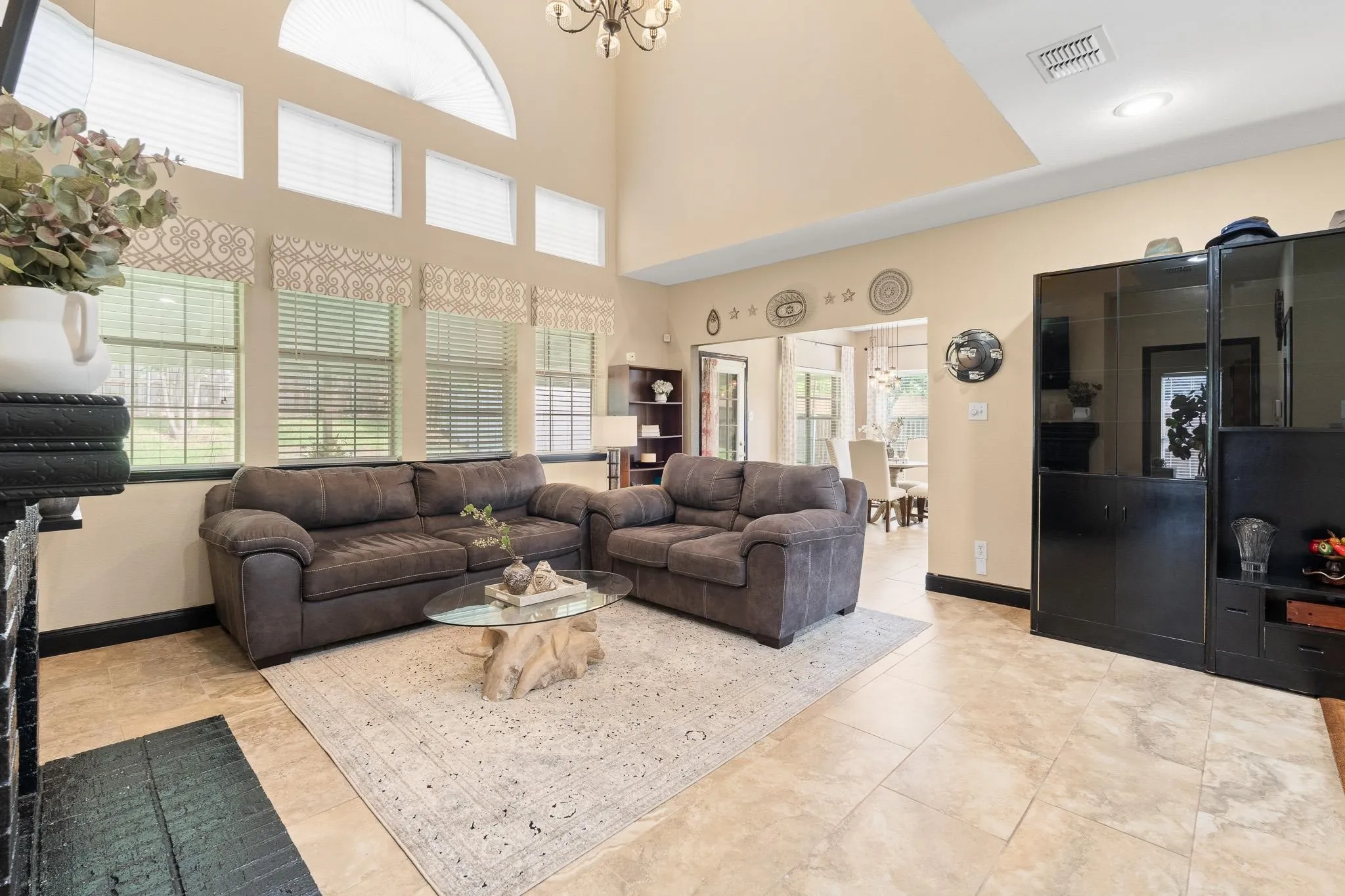 Two-story living area featuring a vaulted ceiling and an arched window