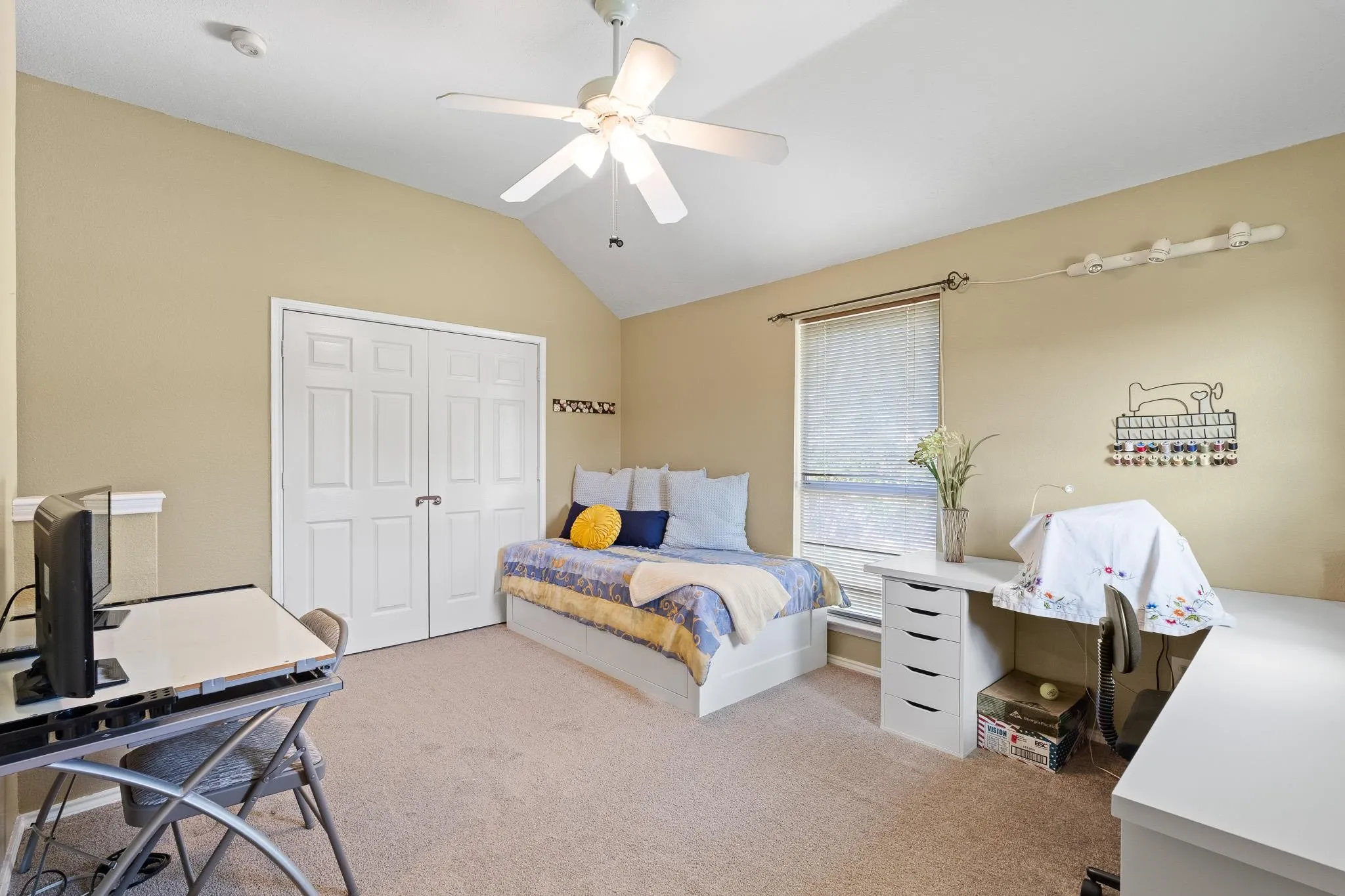 Carpeted room featuring a vaulted ceiling and a ceiling fan