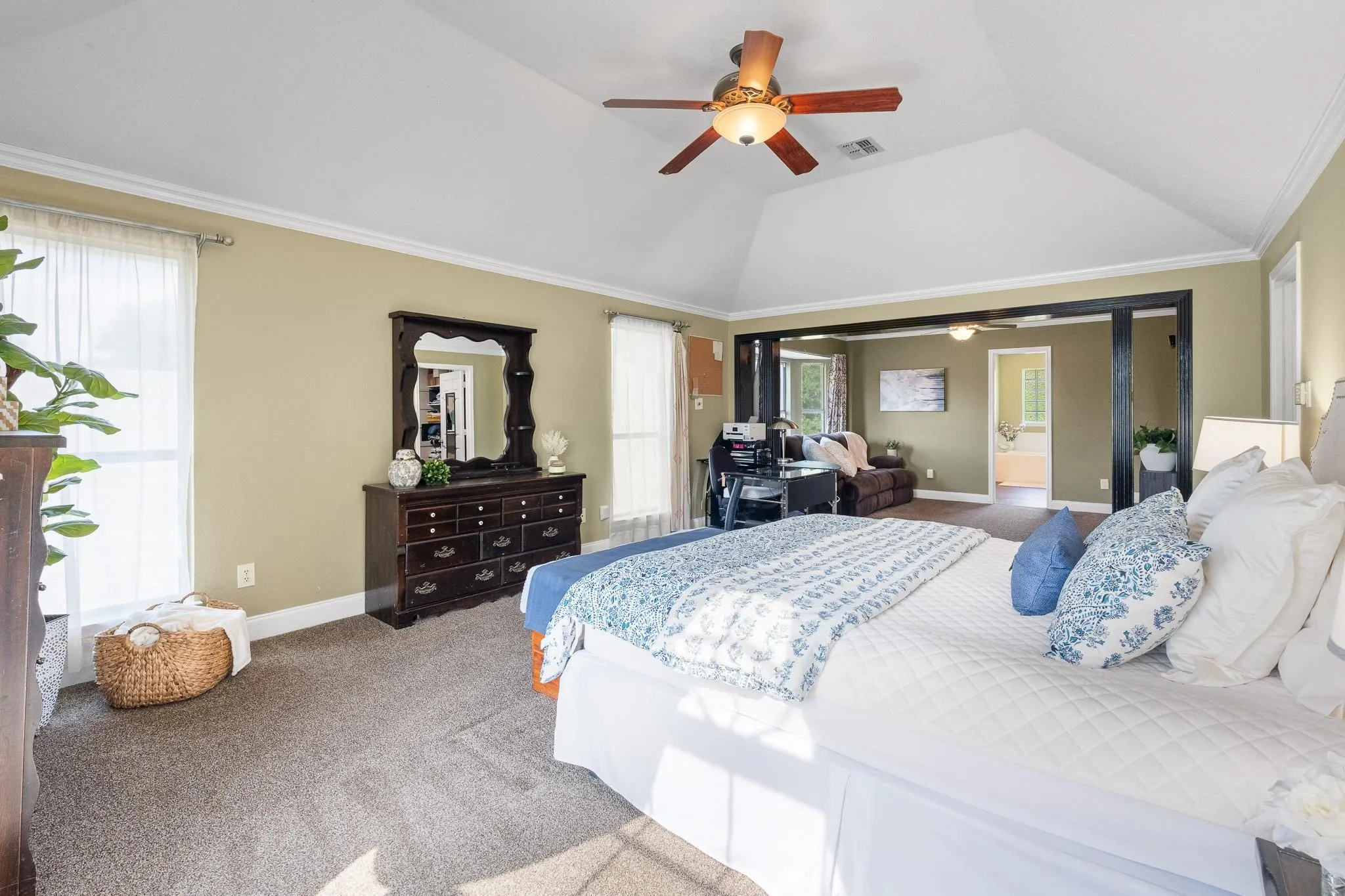 Spacious bedroom featuring vaulted ceilings, a ceiling fan, and carpeted flooring