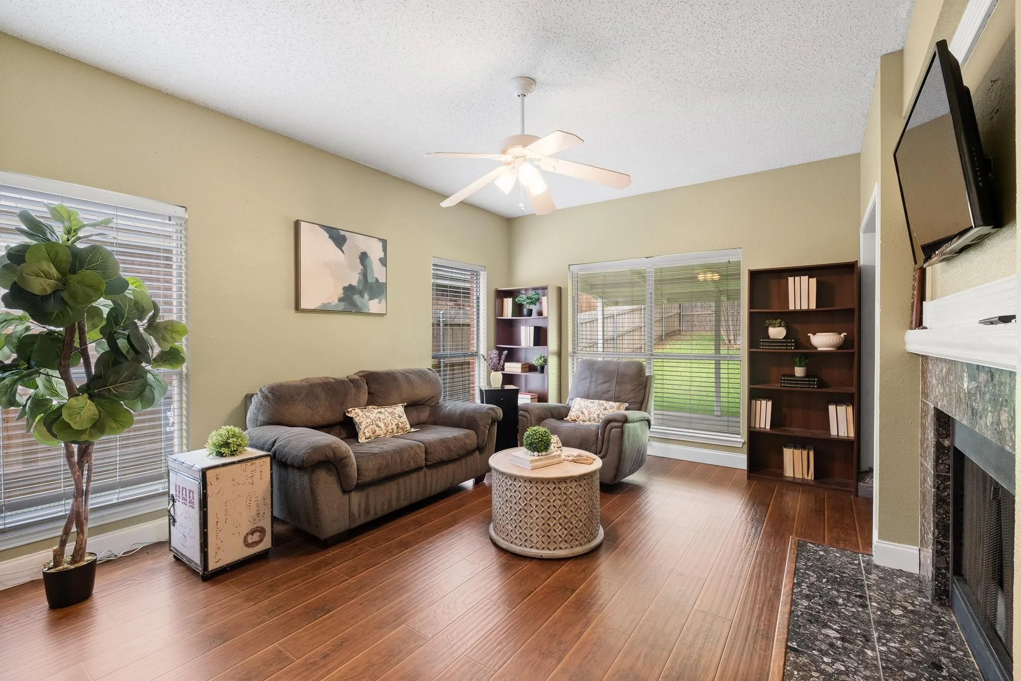 Family room featuring wood-finish flooring, a vaulted ceiling, and a ceiling fan