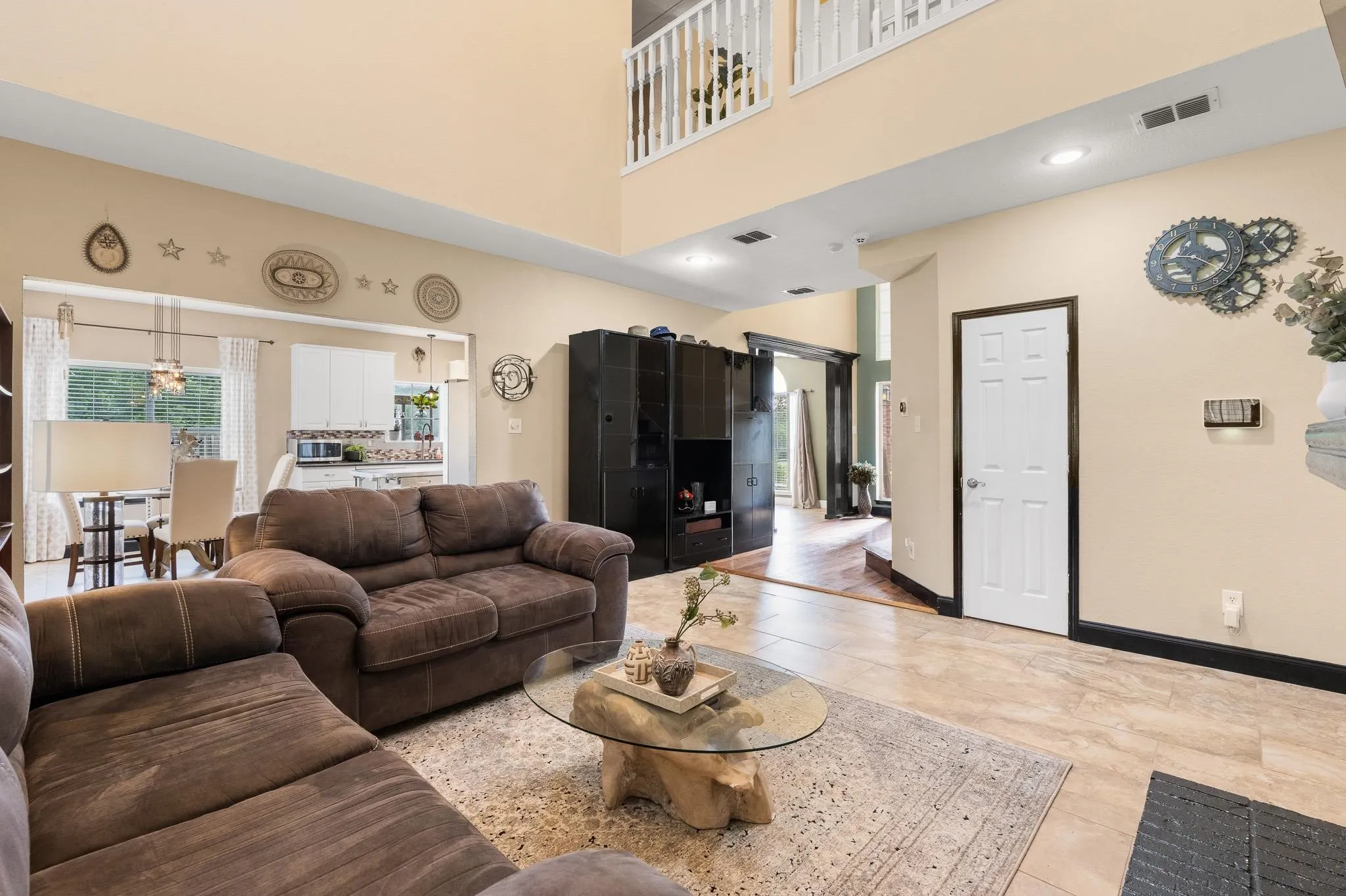 Two-story living area featuring tile flooring, recessed lighting, and an upper-level balcony with white railings