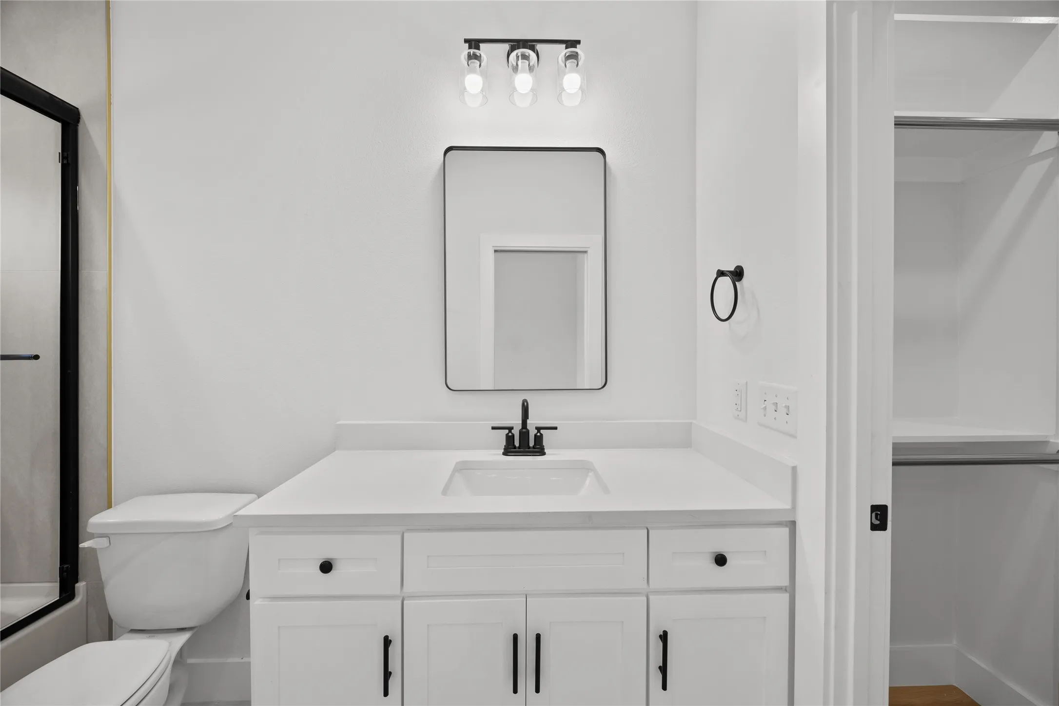 Contemporary bathroom featuring a white vanity with shaker-style cabinetry, a rectangular undermount sink, and a quartz-finish countertop