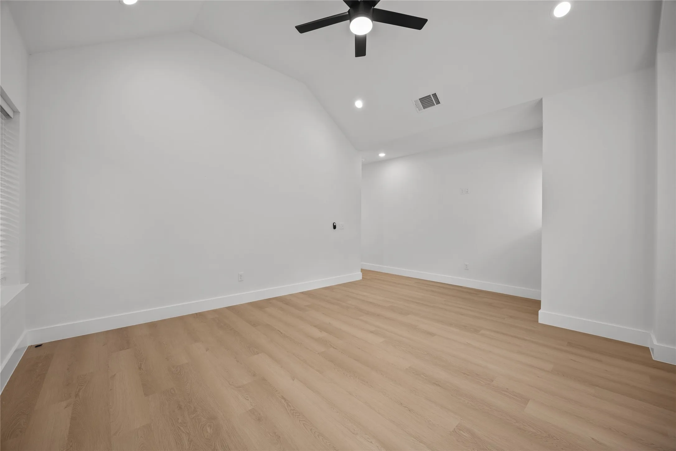 Spacious room with vaulted ceilings and recessed lighting
