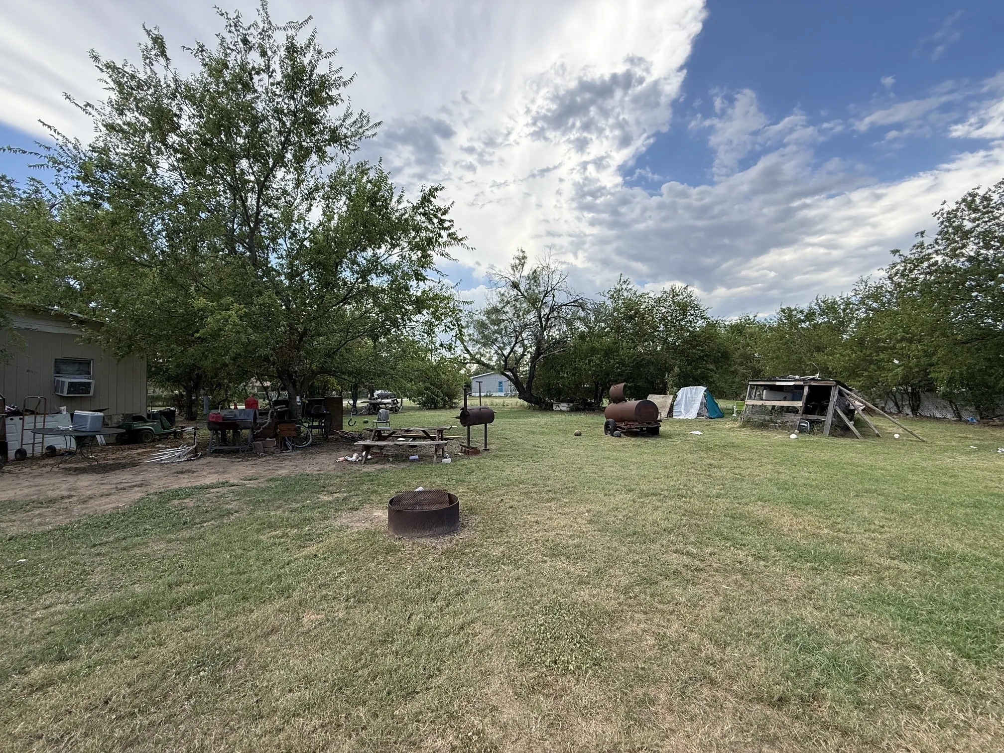 Expansive outdoor area featuring mature trees and a grassy lawn