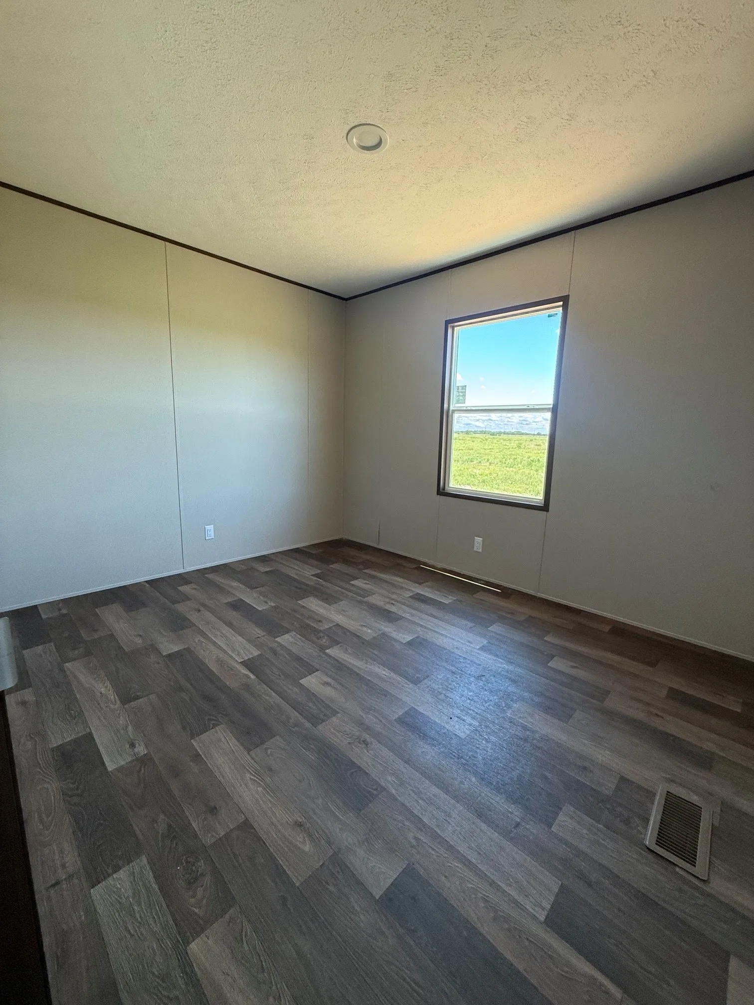 Room featuring wood-finish flooring, neutral wall paneling, and a recessed ceiling light