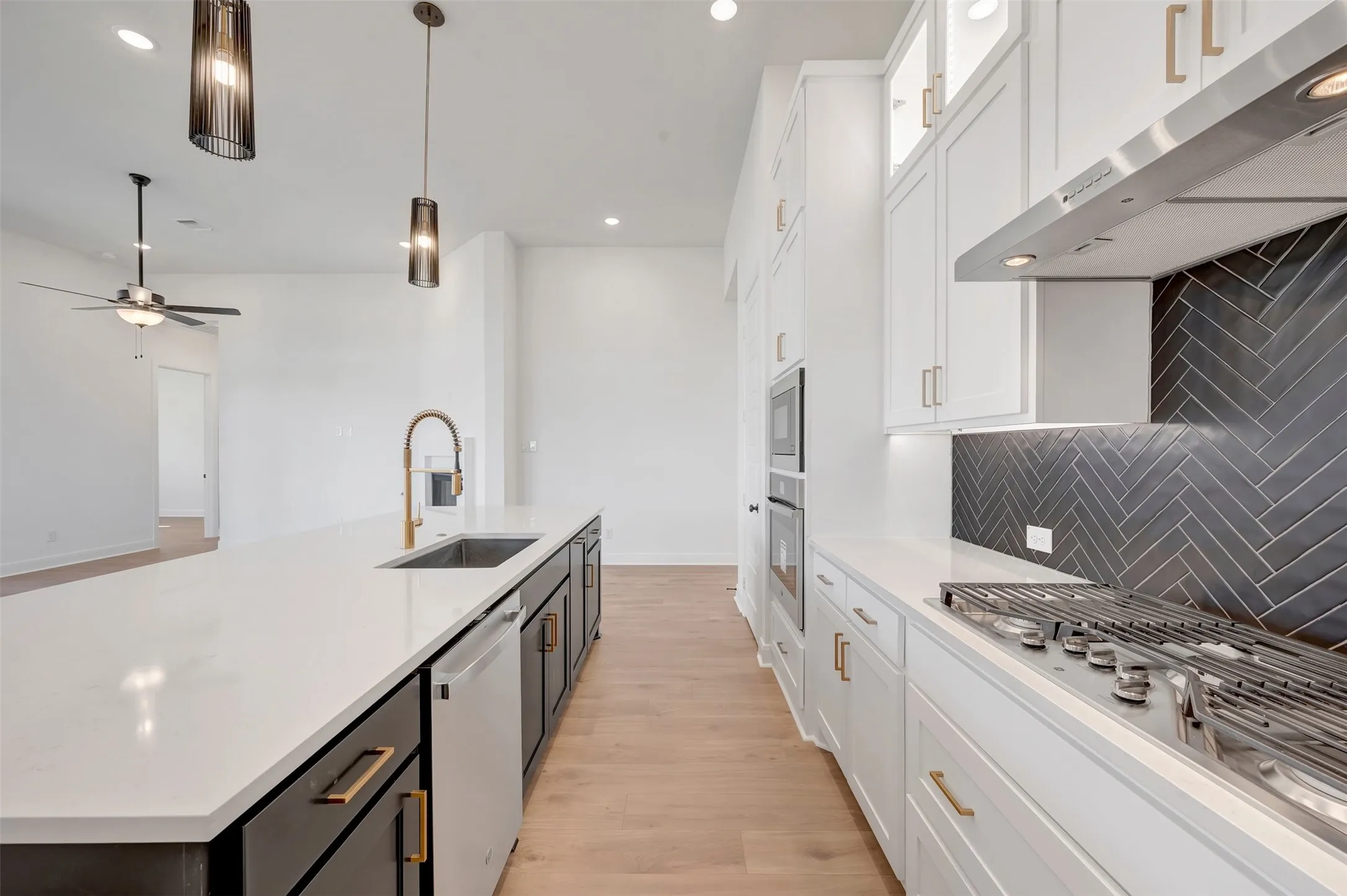 Gourmet kitchen featuring a gas range, built-in double ovens, and a herringbone tile backsplash