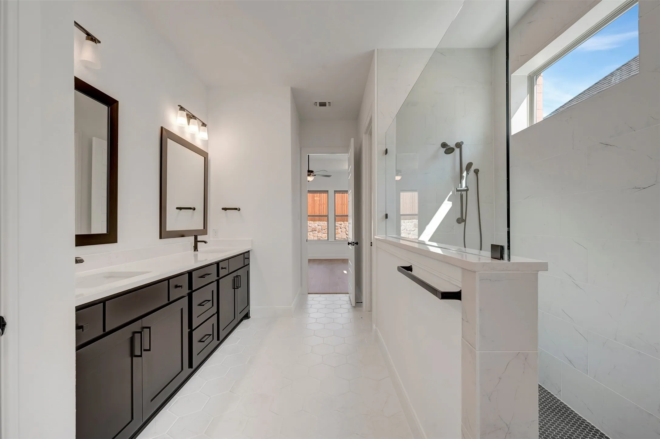 Dual vanity with dark wood-finish cabinetry, white countertops, and framed mirrors
