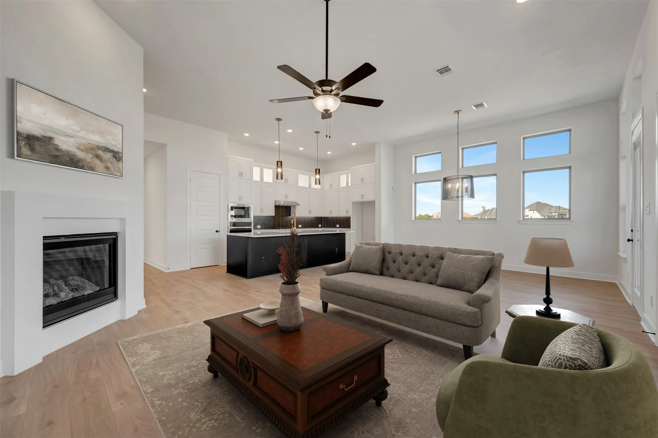 Vaulted ceiling, recessed lighting, fireplace, wood-finish flooring, and multiple transom windows