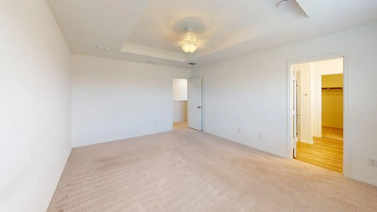 Spacious room featuring neutral carpet flooring and white walls