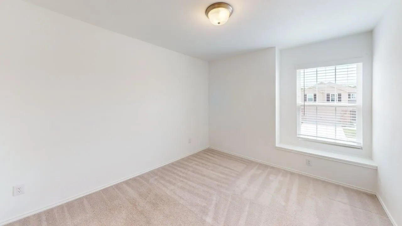 Room featuring neutral tone carpet, white walls, a single window with blinds, and a built-in window seat