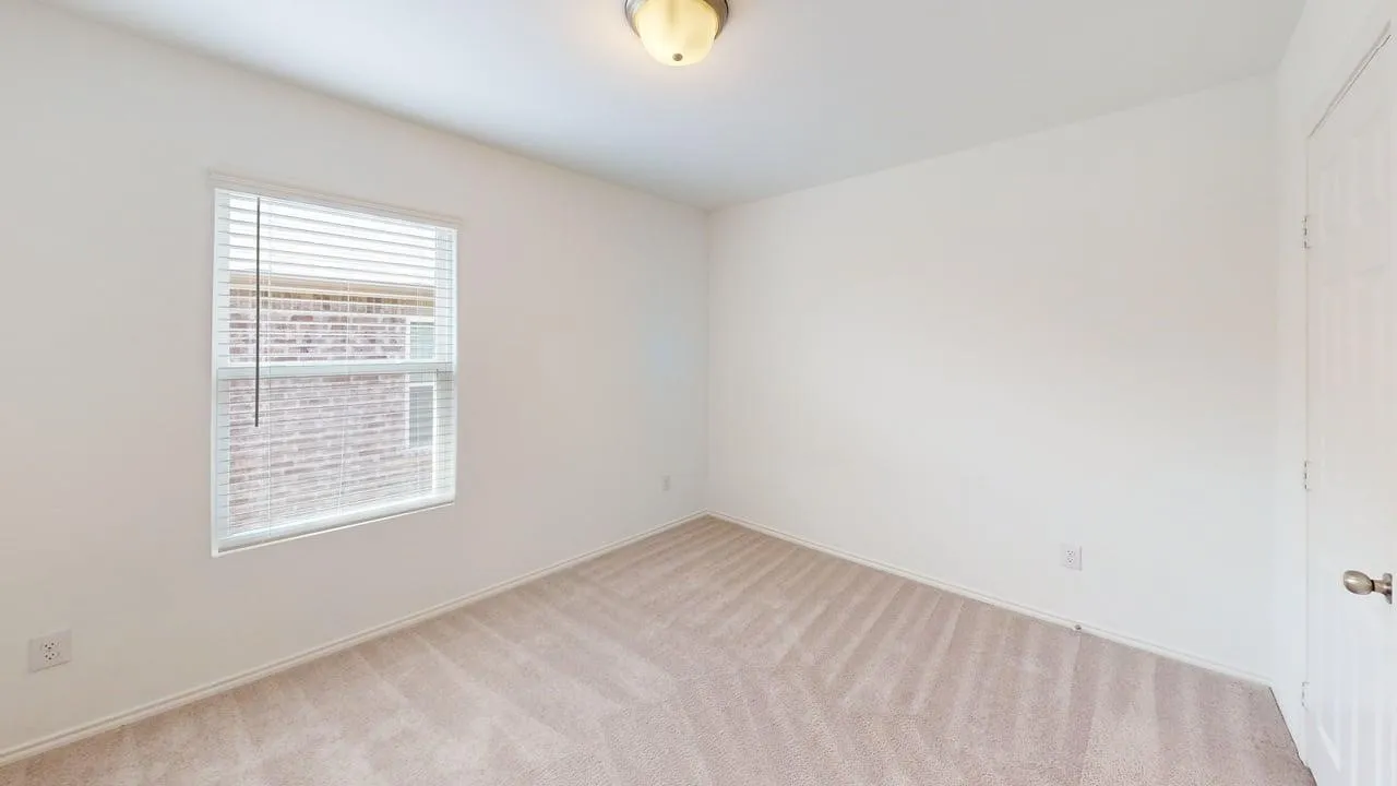 Room with neutral-toned carpet, a window with horizontal blinds, and a flush mount ceiling light fixture