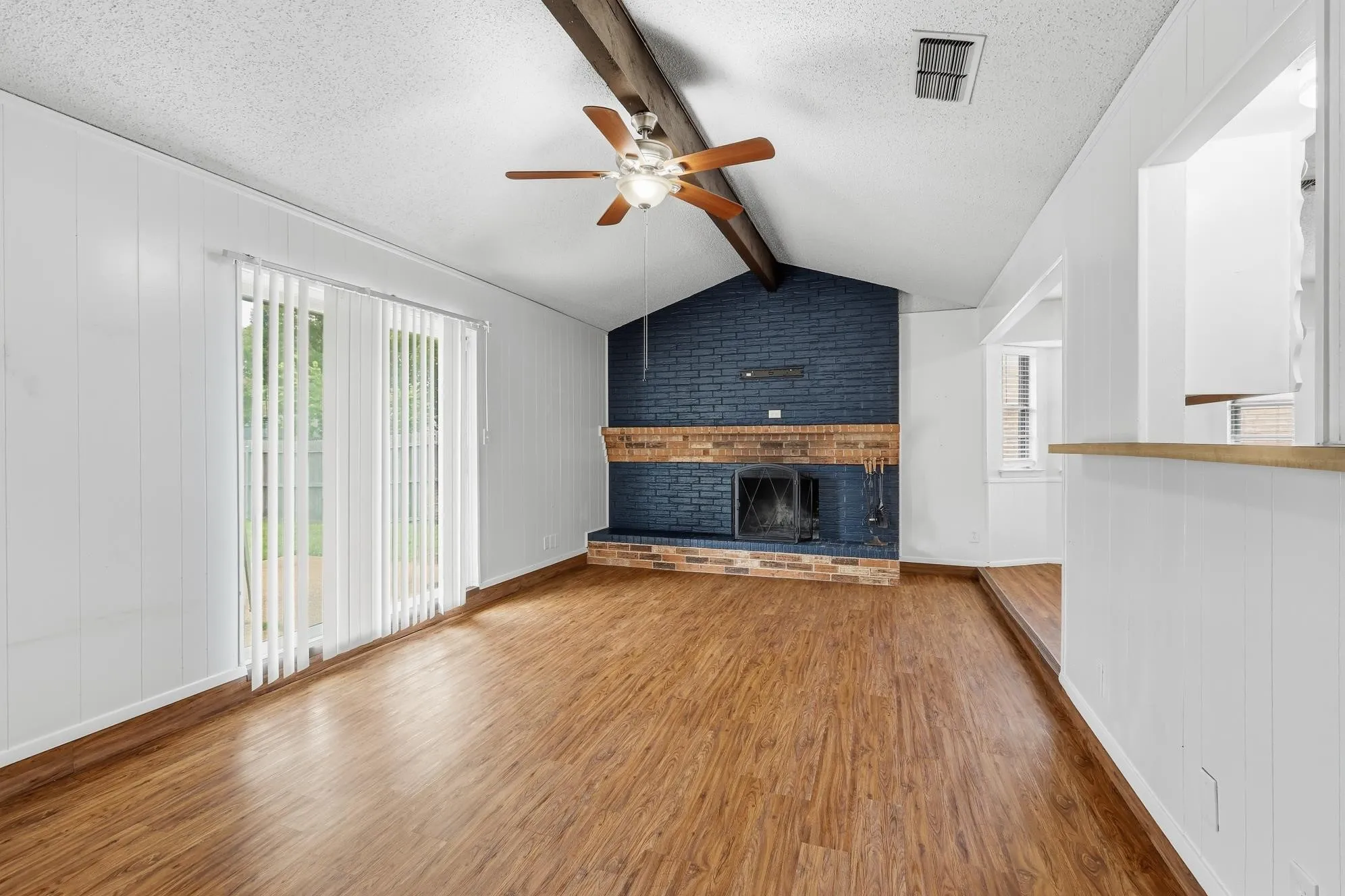 Open-concept living area showcasing vaulted ceilings, architectural beam details.