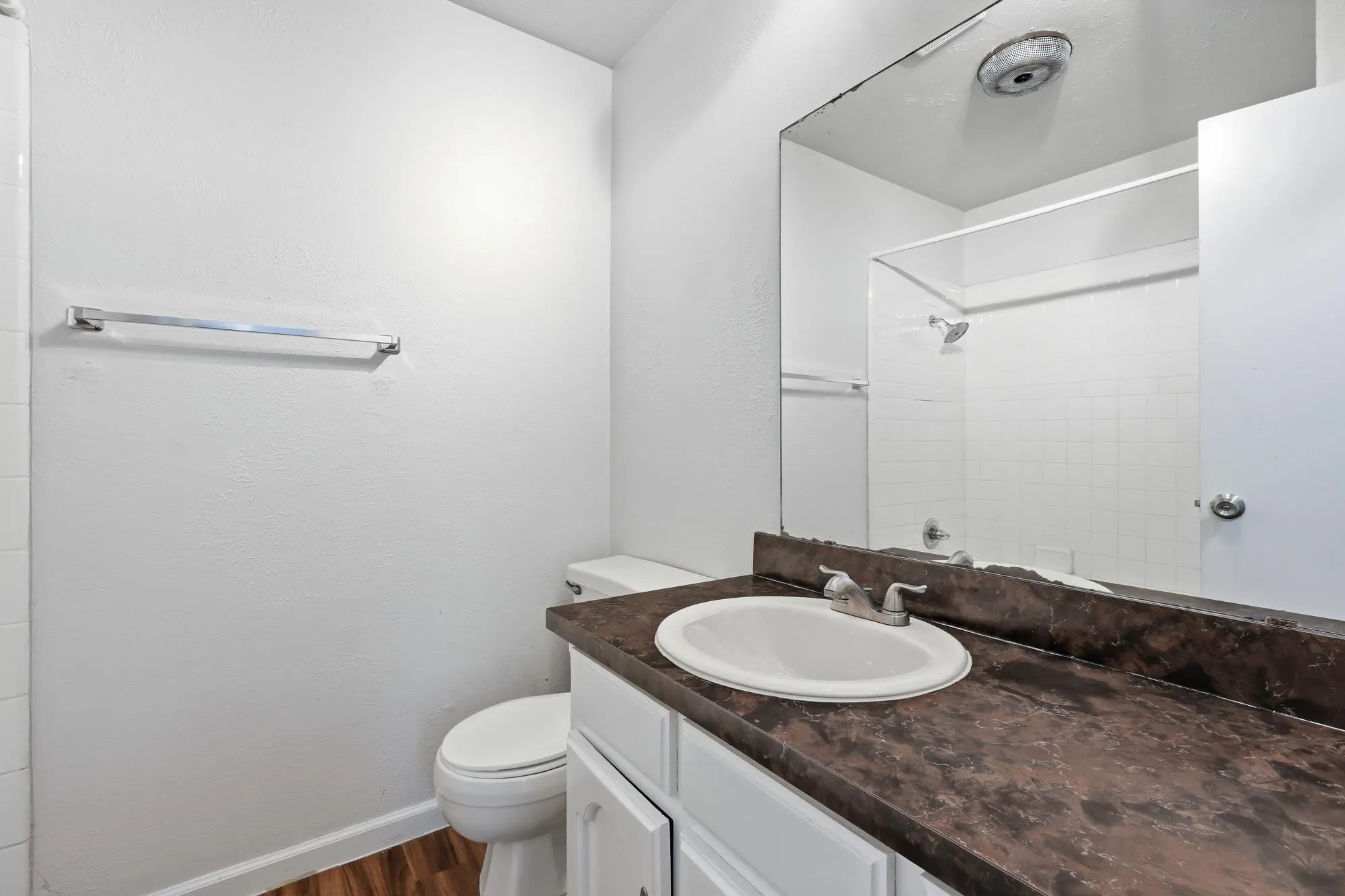 Well-maintained guest bathroom offering a large vanity, abundant storage, and a classic shower-tub combination.