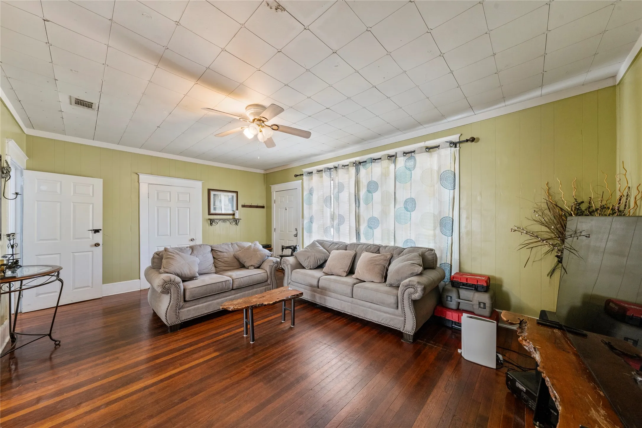 Hardwood flooring, ceiling fan, crown molding, paneled walls, multiple windows