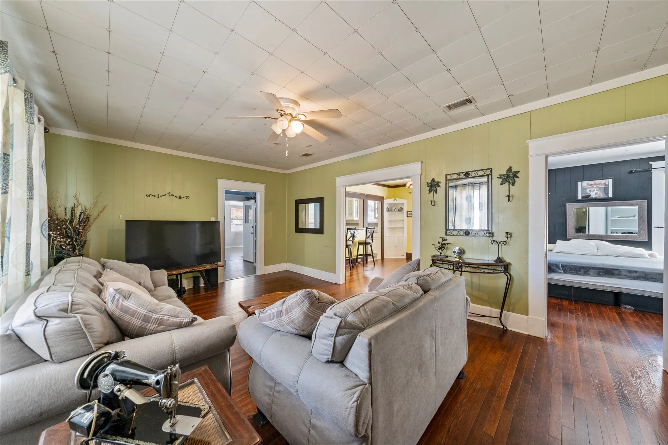 Hardwood flooring extends throughout, complemented by a ceiling fan with integrated lighting