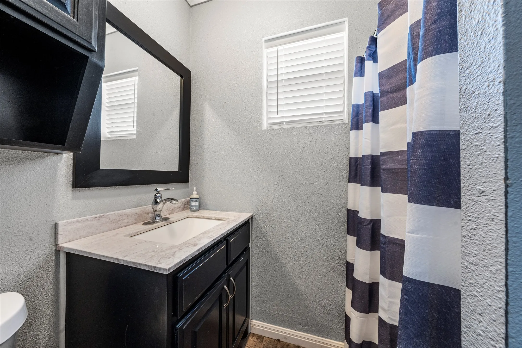 Black vanity with an integrated sink and light-colored countertop
