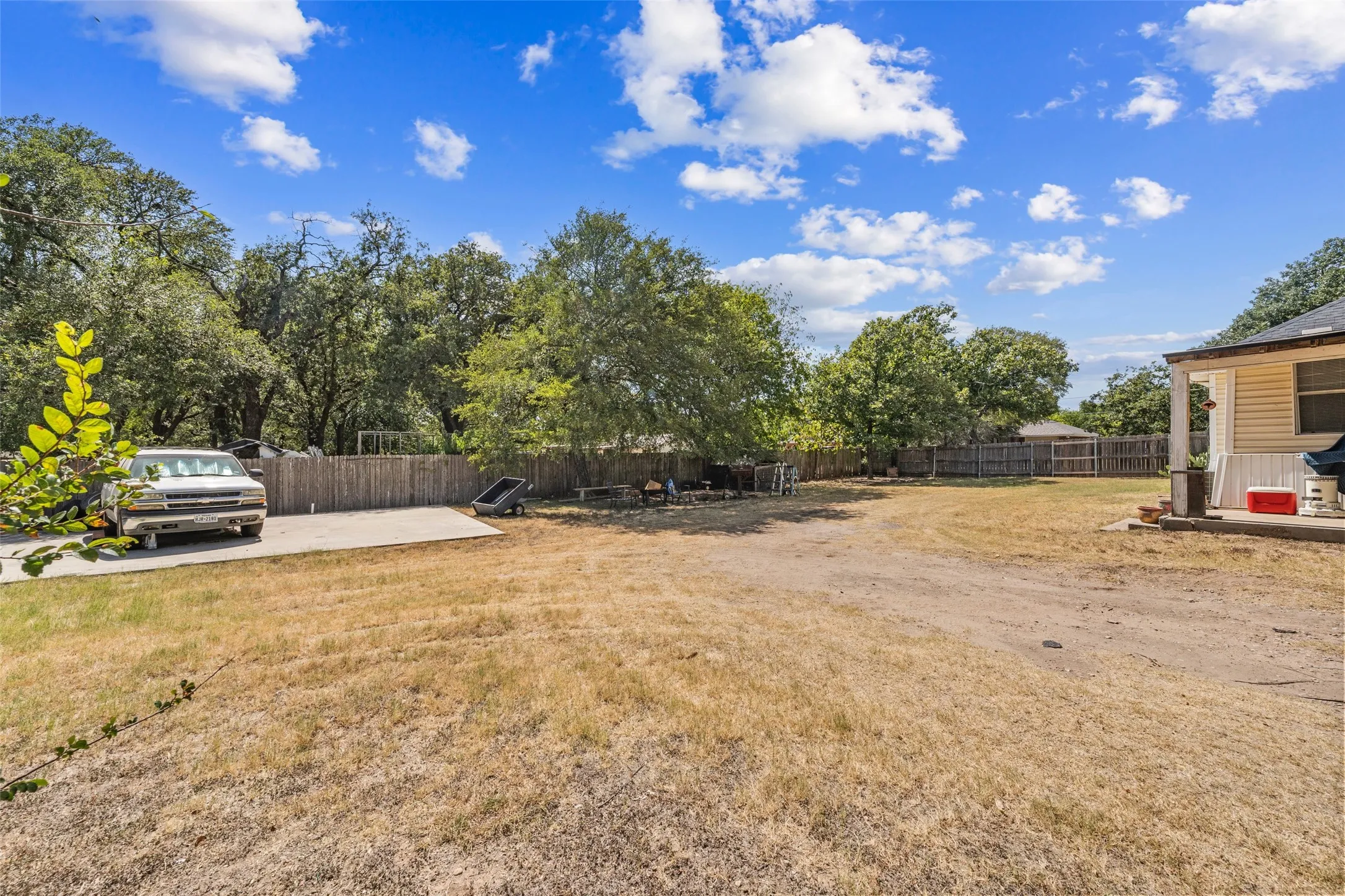 Expansive outdoor area with a gravel surface and mature perimeter trees